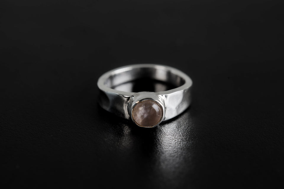 Eternal Rose Quartz Hammered Ring shown on black background with soft pink gemstone and polished silver band.