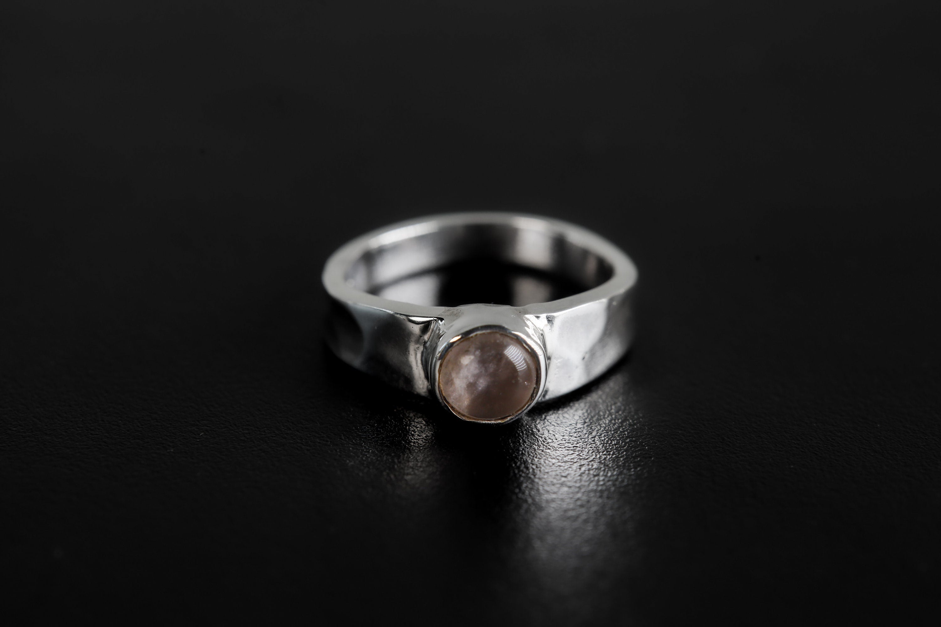 Eternal Rose Quartz Hammered Ring shown on black background with soft pink gemstone and polished silver band.