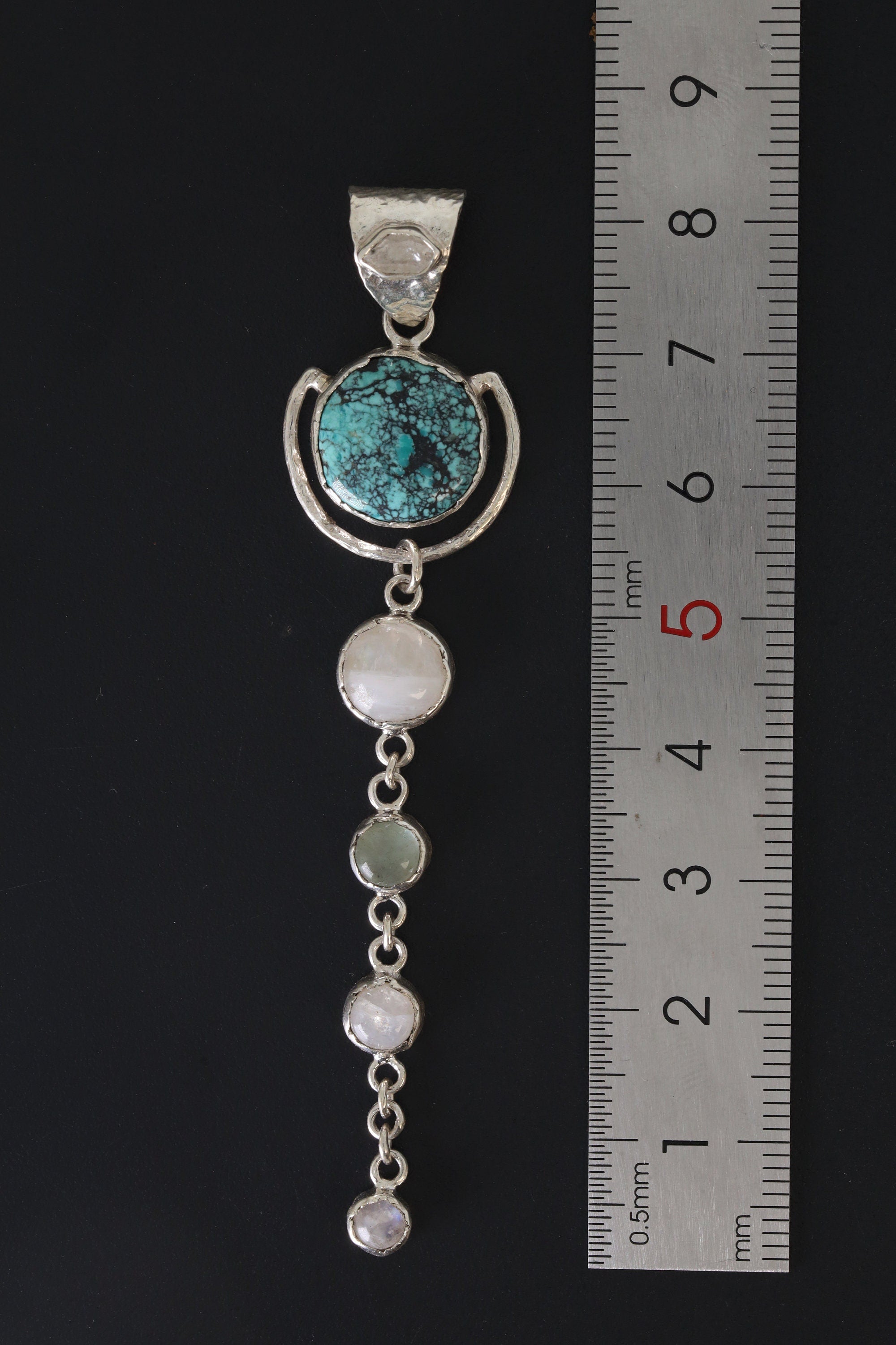 Turquoise Moonstone pendant shown beside a ruler for scale, measuring approximately 8 cm long and 2 cm wide.