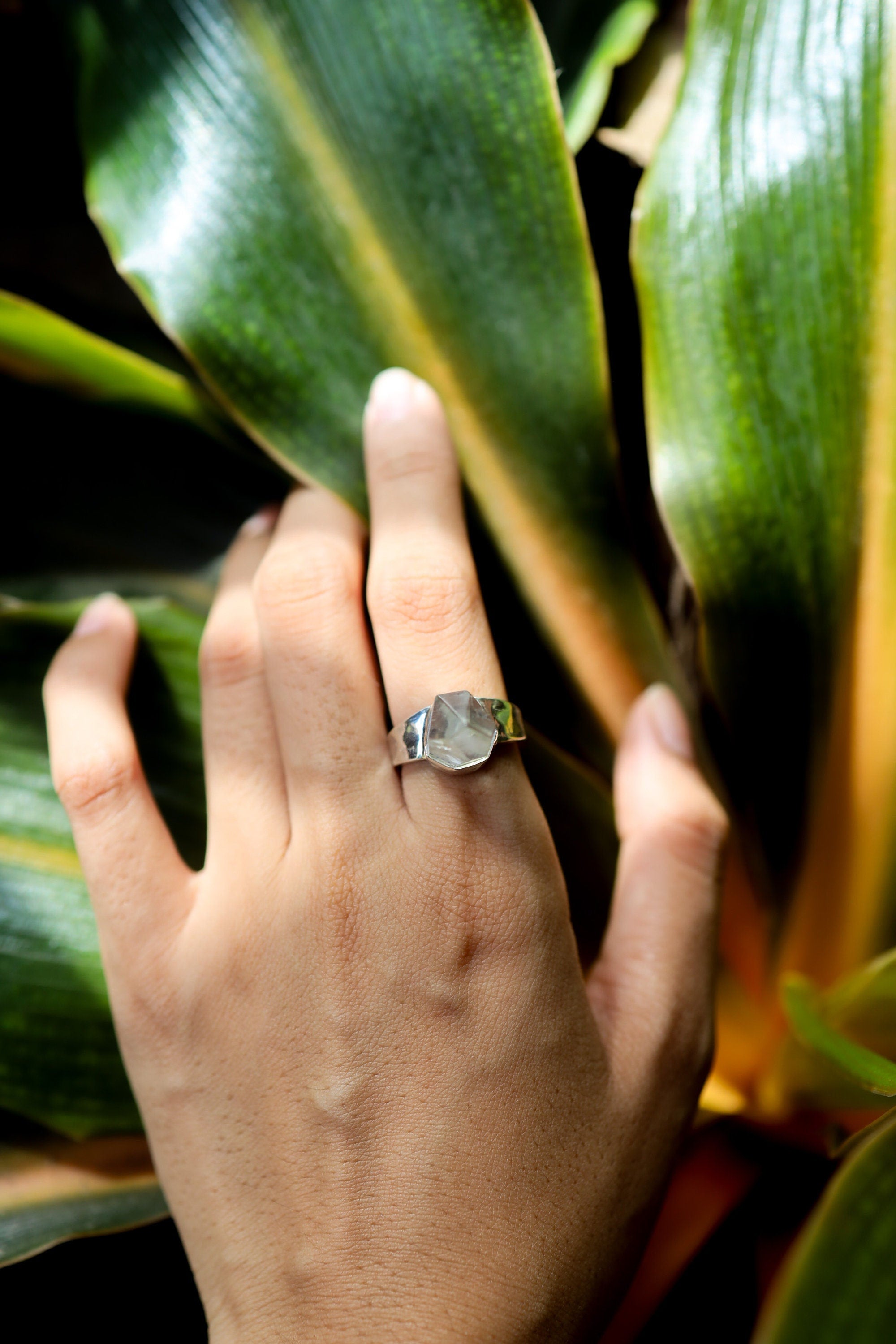 Cacoxenite Quartz point ring shown from the side on a dark background, with sharp crystal form and hammered silver detail.