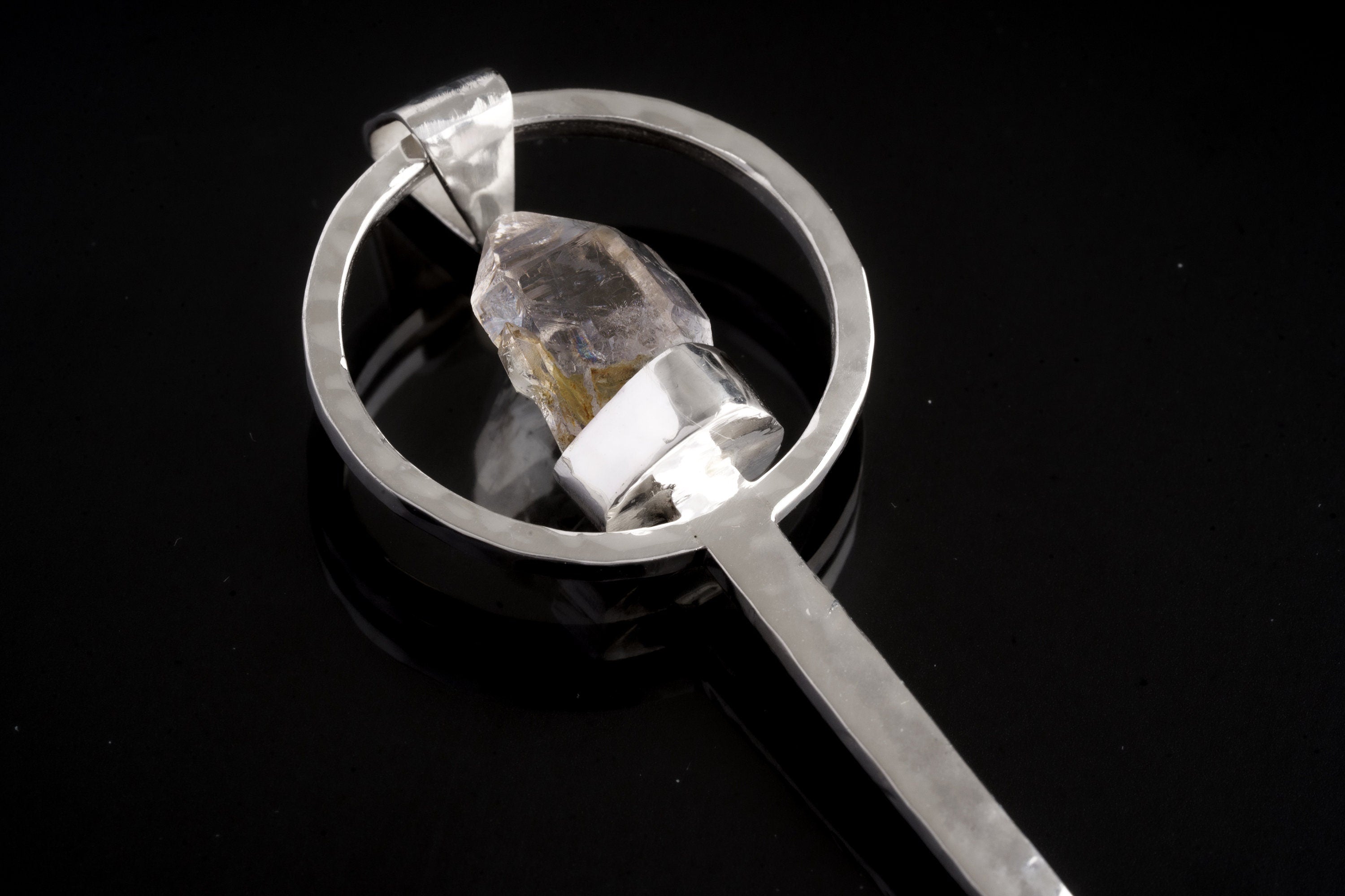 Close-up of Vera Cruz Amethyst spoon pendant showing oxidized hammered silver texture and pale purple crystal.
