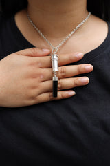 Large Black Tourmaline capsule pendant shown worn on a model, with silver chain and functional keepsake vessel design.