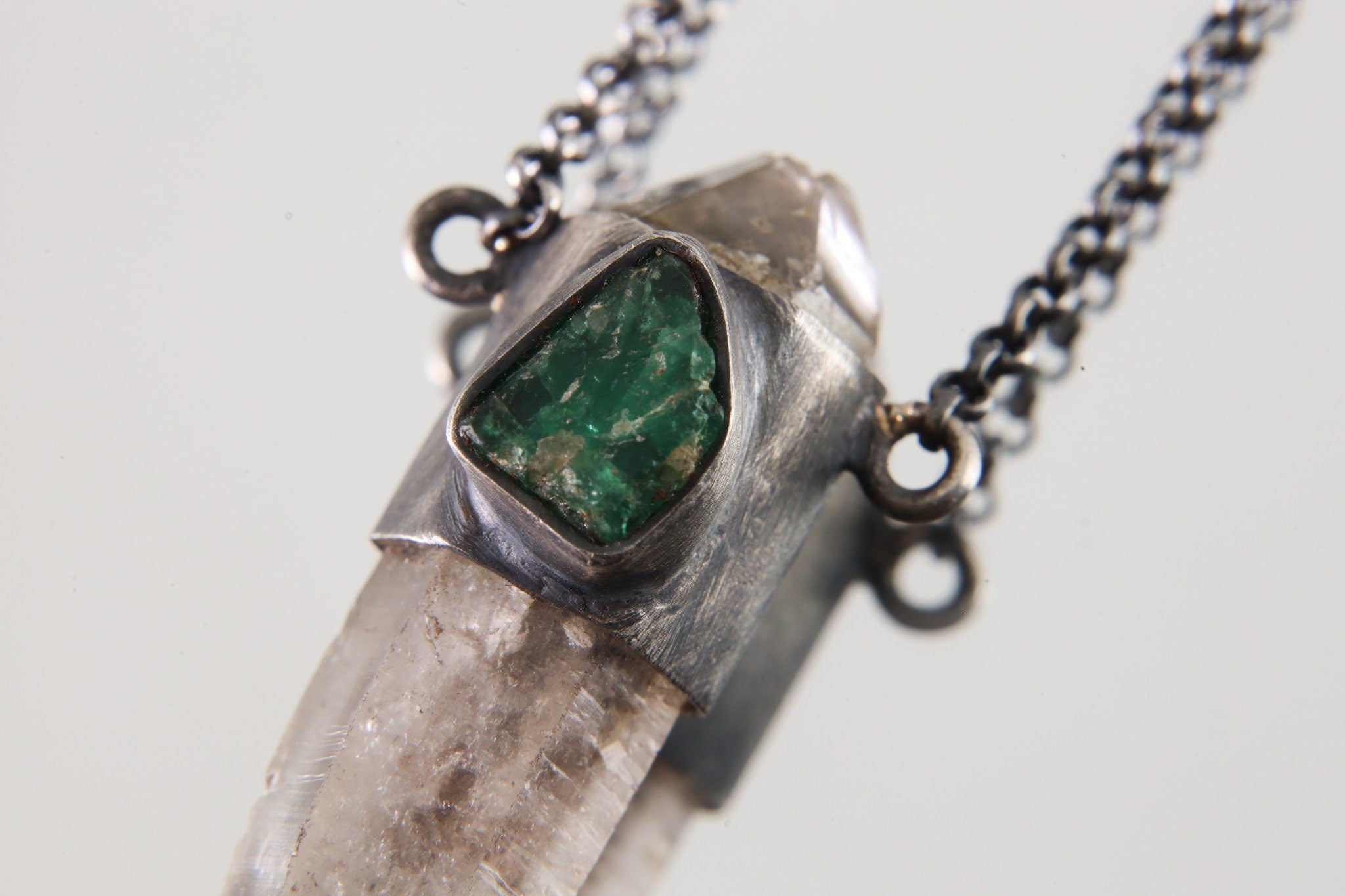 Close-up of Vera Cruz Amethyst Emerald Pendant showing oxidized sterling silver wrap and green Emerald accent.