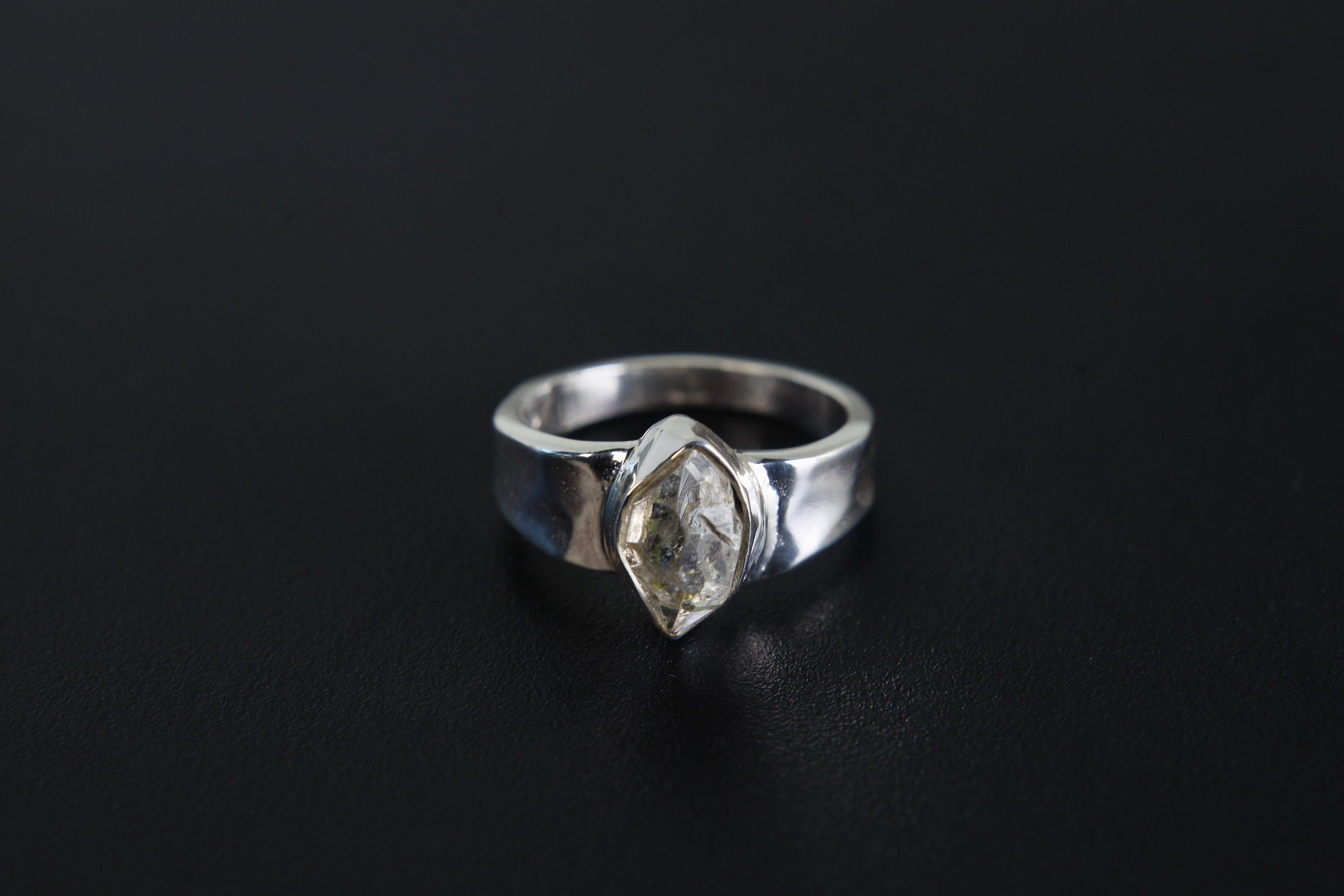 Crystal Clarity Herkimer Diamond Ring shown on black background with hammered sterling silver and clear crystal focal point.