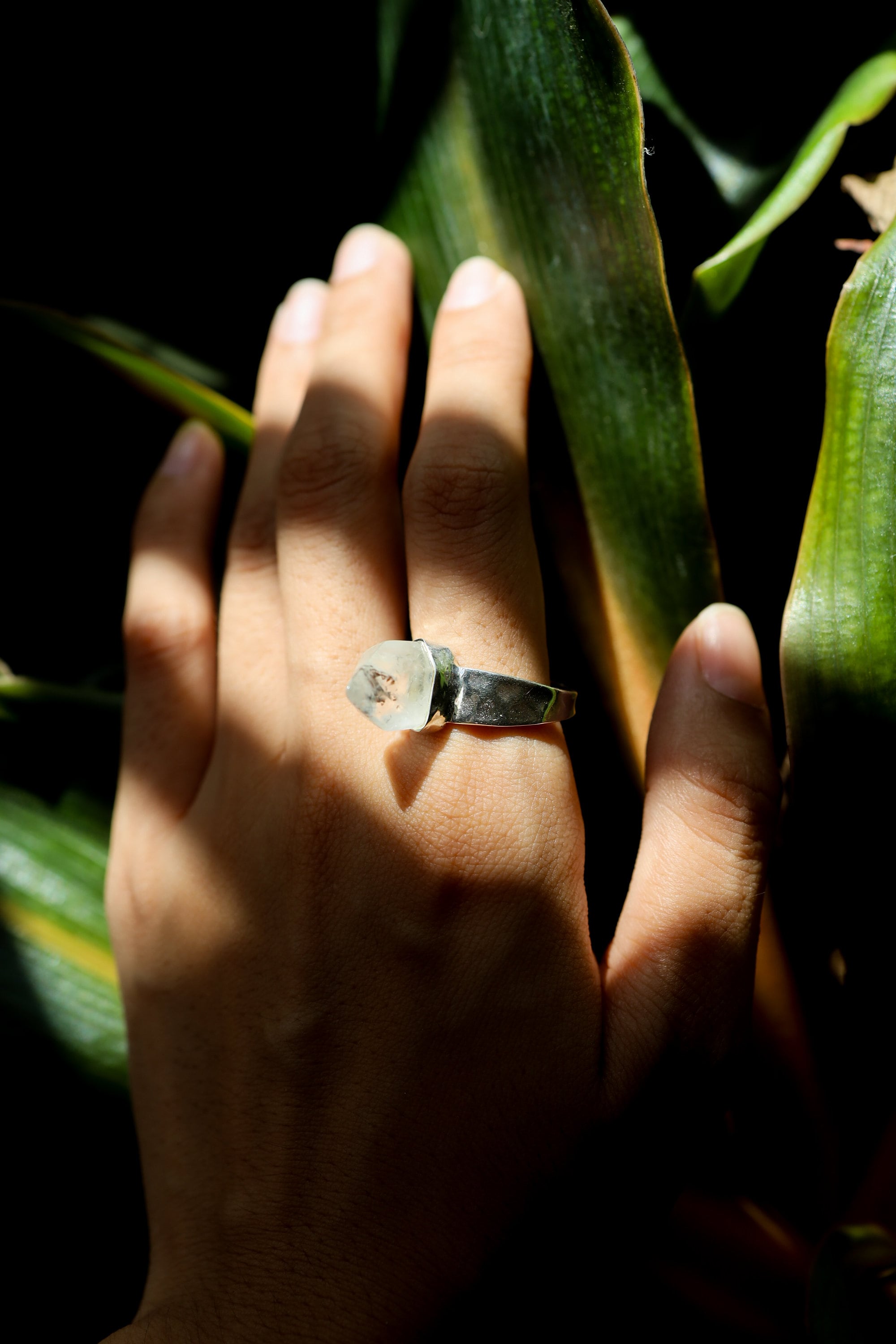 Cacoxenite Quartz point ring shown worn on the hand, with golden-brown inclusions and shiny hammered sterling silver band.