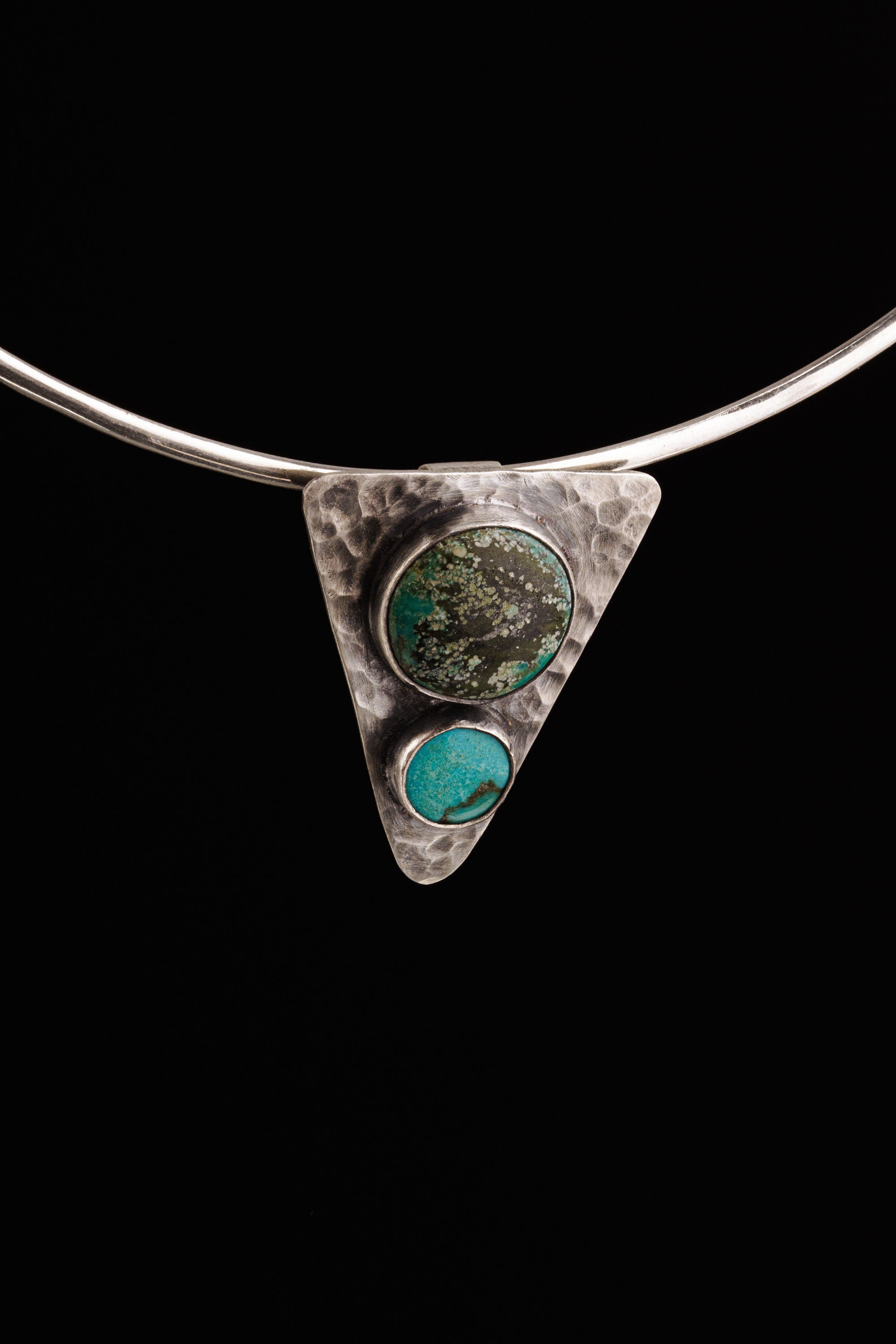 Turquoise Triangle Spirit Pendant displayed on silver choker against black background.