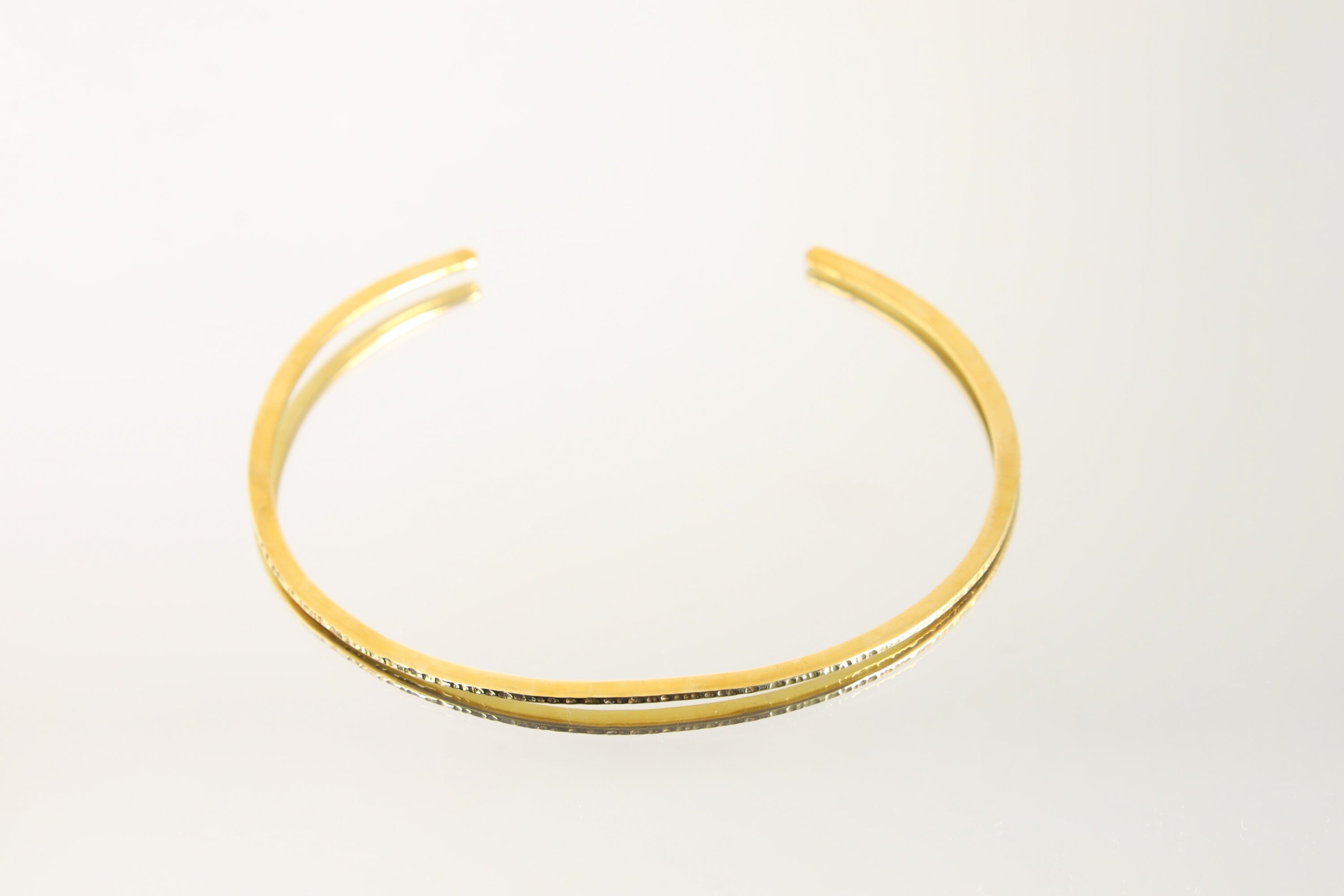 Gold-plated brass choker shown worn on a model, with open neck cuff shape and warm minimalist collar styling.