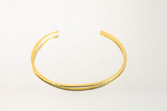 Gold-plated brass choker shown worn on a model, with open neck cuff shape and warm minimalist collar styling.