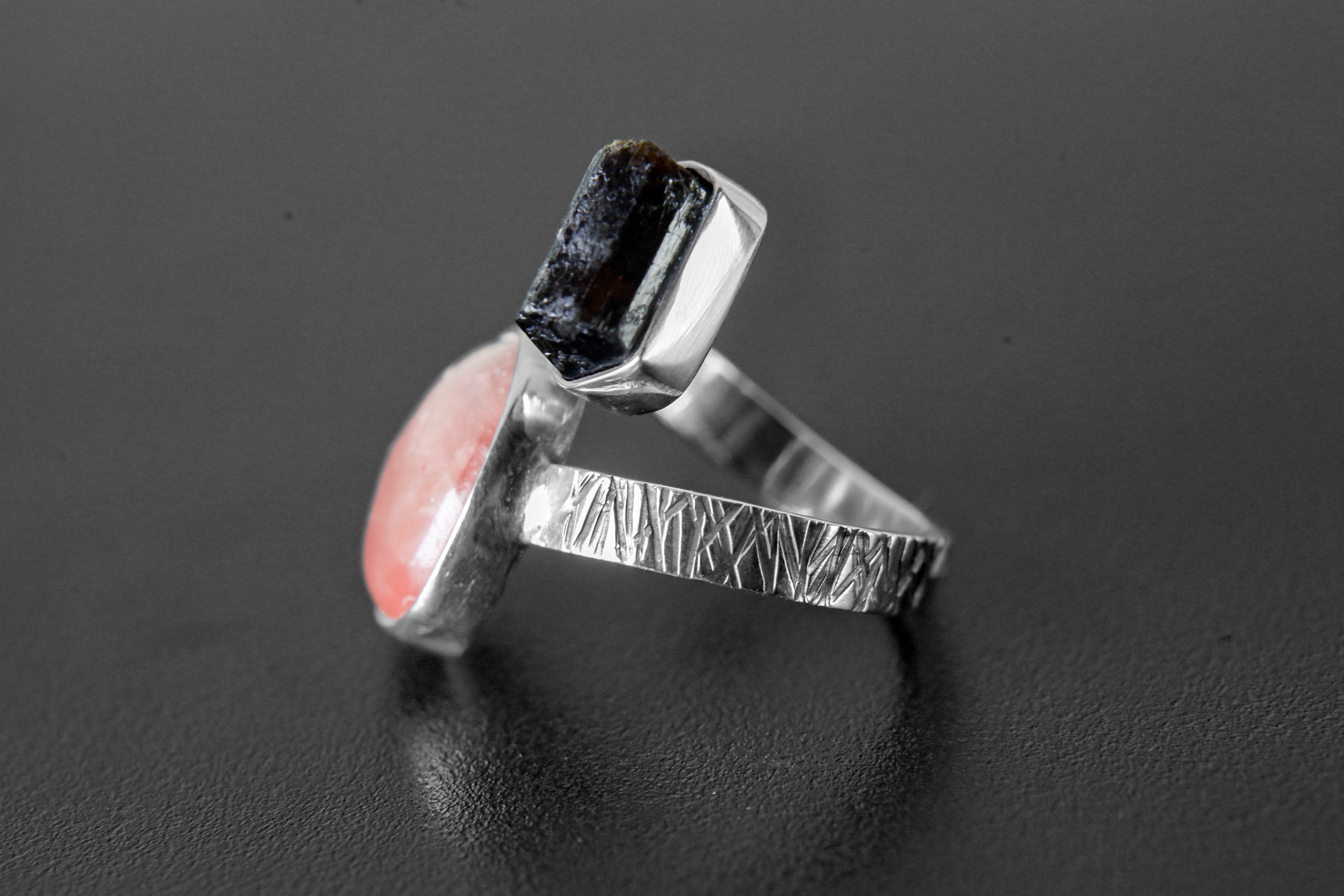 Side view of adjustable Dravite Tourmaline Sunstone ring showing open band, bezel settings, and textured silver detail.