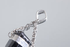 Black Tourmaline protection pendant shown with chain on white background and handmade silver detail.