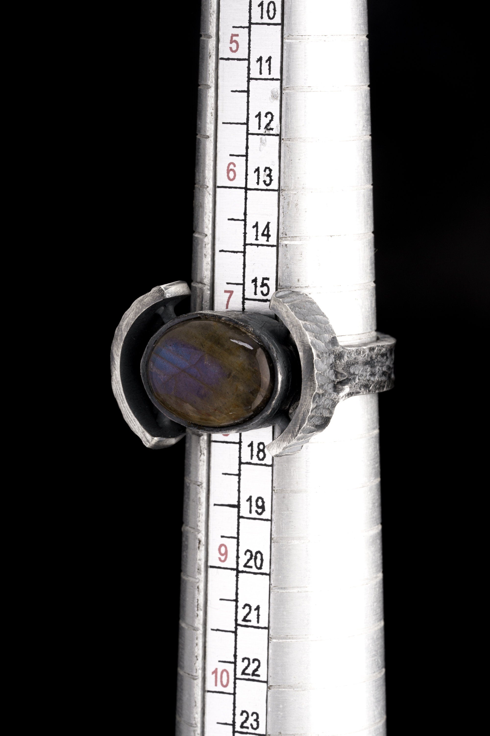 Oval Labradorite Oxidized Silver Ring shown beside a ruler for scale with wide 925 silver band and oval gemstone.