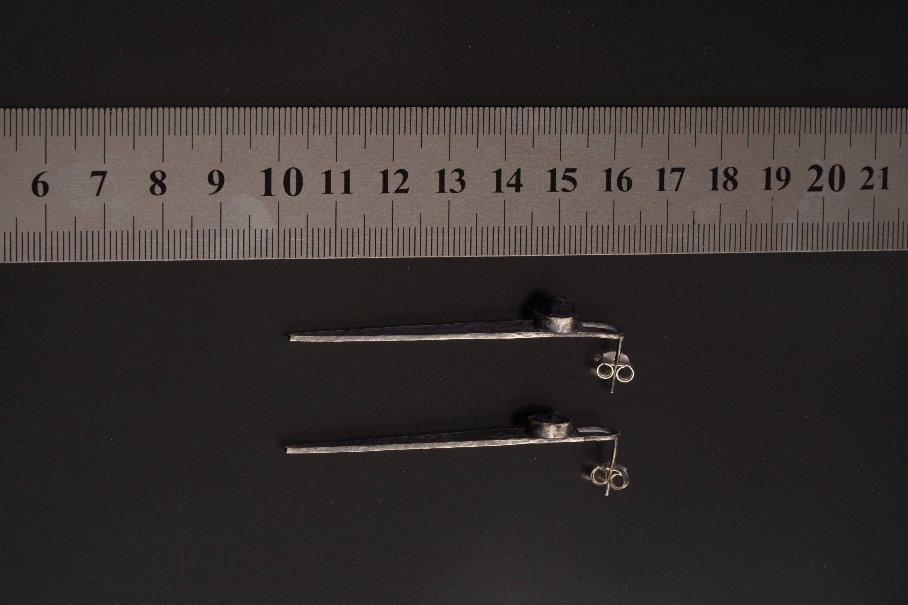 Oxidized Sapphire hammered sterling silver earrings shown beside a ruler for 8 cm length reference.