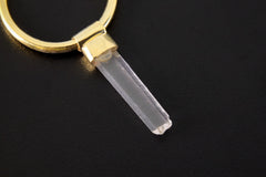 Close-up of Clear Quartz hoop earring pendant showing prong-set crystal and warm gold-plated detail.