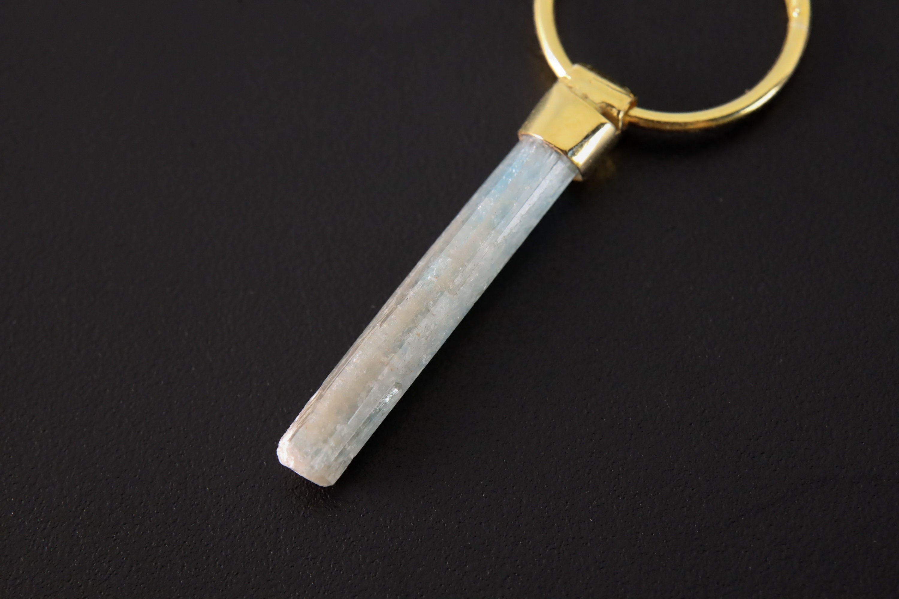 Close-up of Australian Aquamarine convertible earrings showing pale blue charms and warm gold-plated silver hoops.