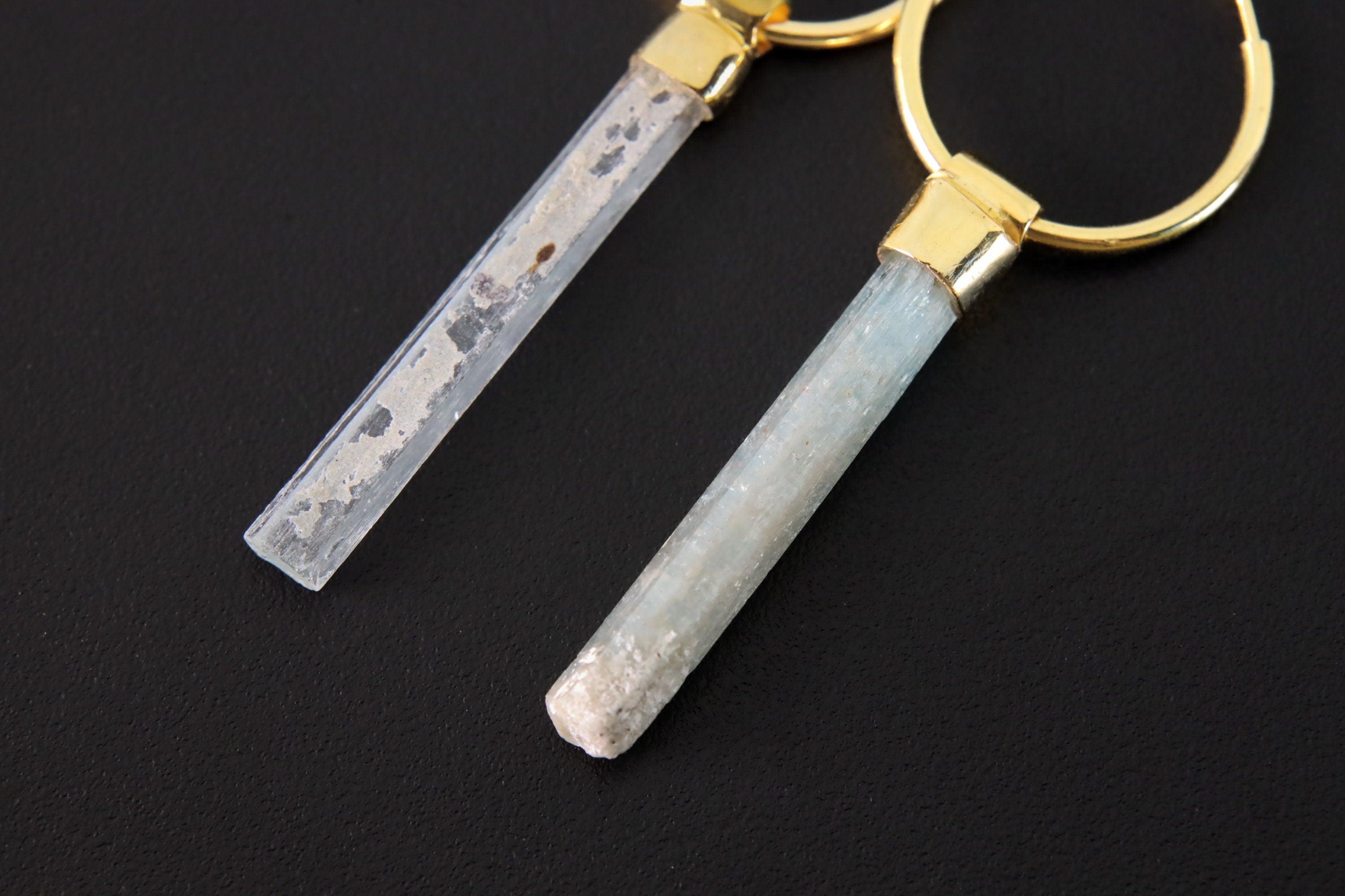 Close-up of Australian Aquamarine convertible earrings showing pale blue charms and warm gold-plated silver hoops.