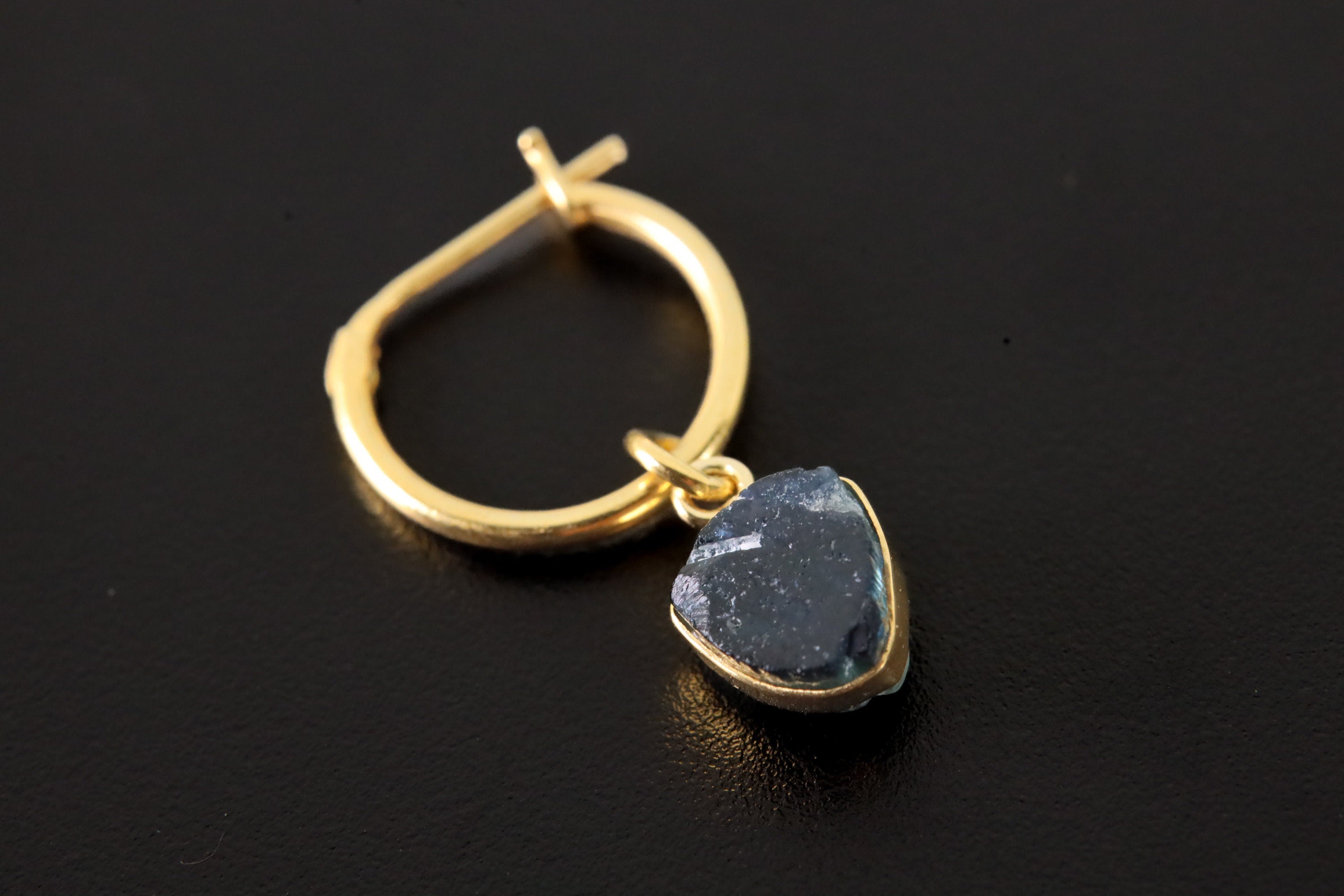 Close-up of Blue Tourmaline convertible earring showing raw Indicolite slice and warm gold-plated hoop fitting.