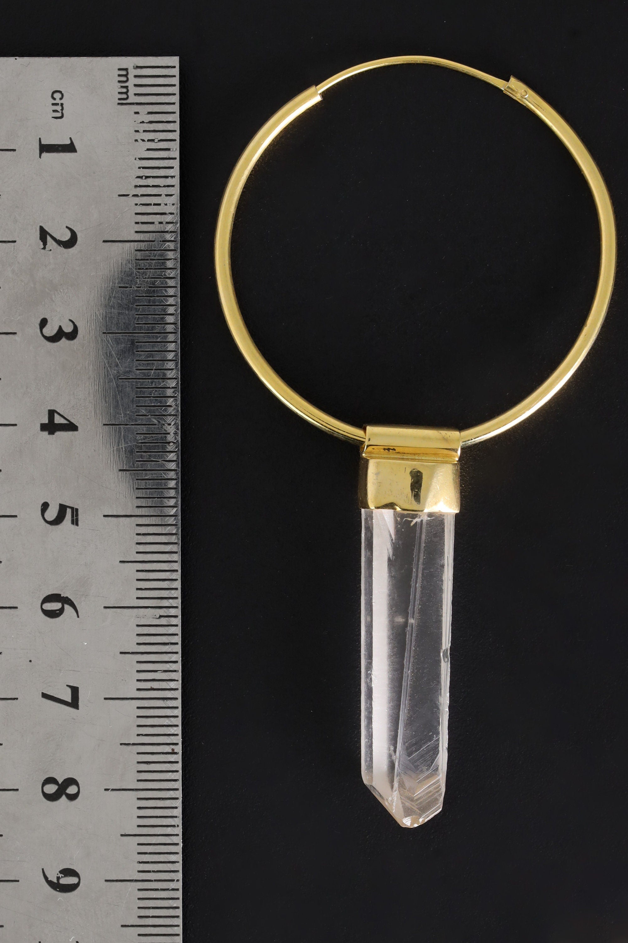 Lemurian Quartz gold-plated hoop earring pendant shown beside a ruler for scale as one single piece.