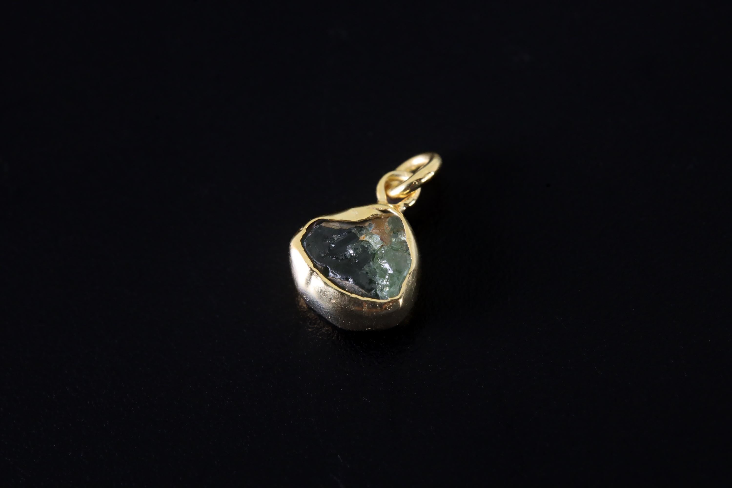 Green Tourmaline gold-plated sterling silver hoop earring worn on a model as a single dangle charm.