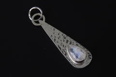 Lunar Teardrop Blue Moonstone pendant shown on dark background with shiny hammered sterling silver and blue flash stone.