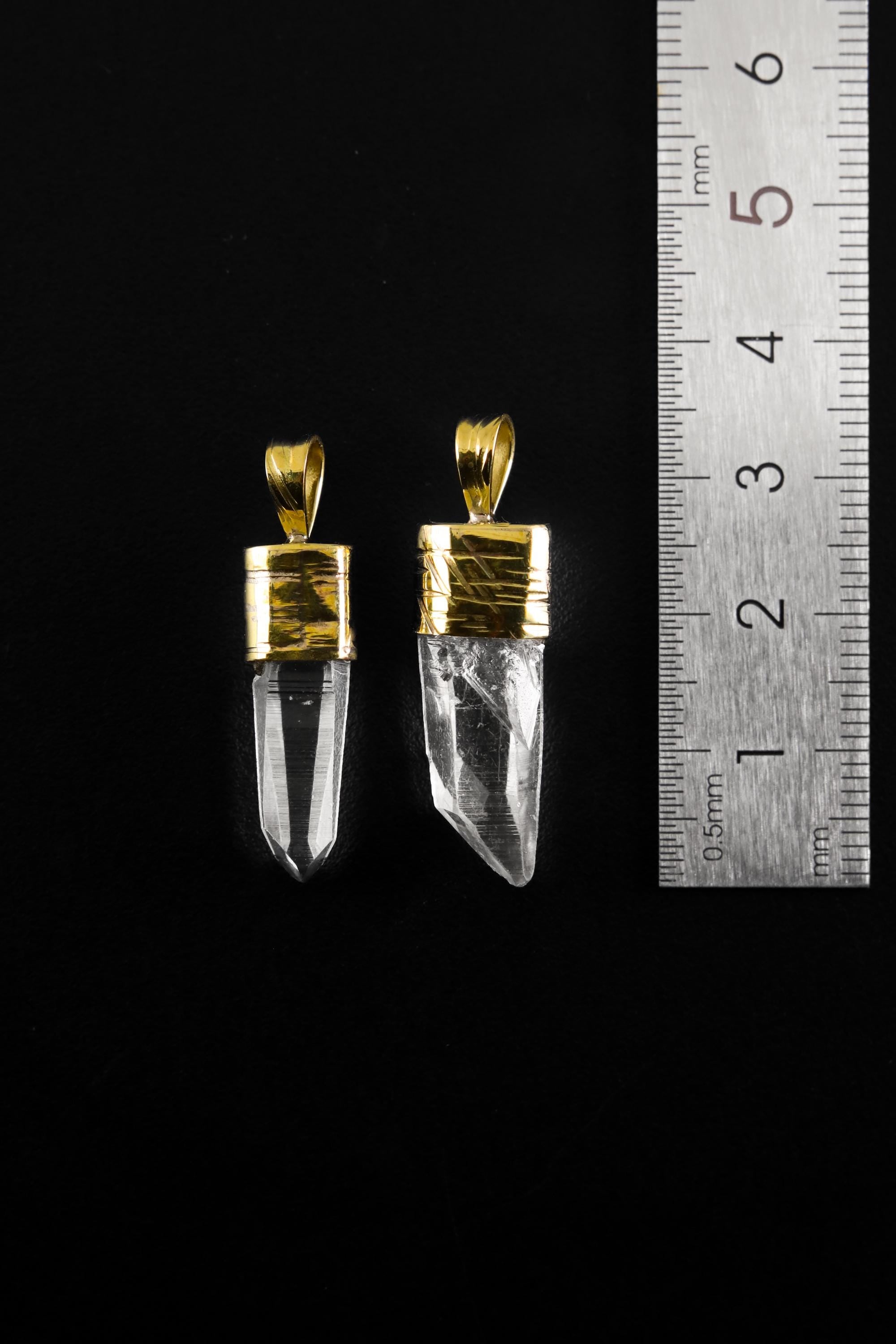 Australian Quartz point pendants shown beside a ruler for scale, measuring approximately 3 to 3.5 cm total length including bail.