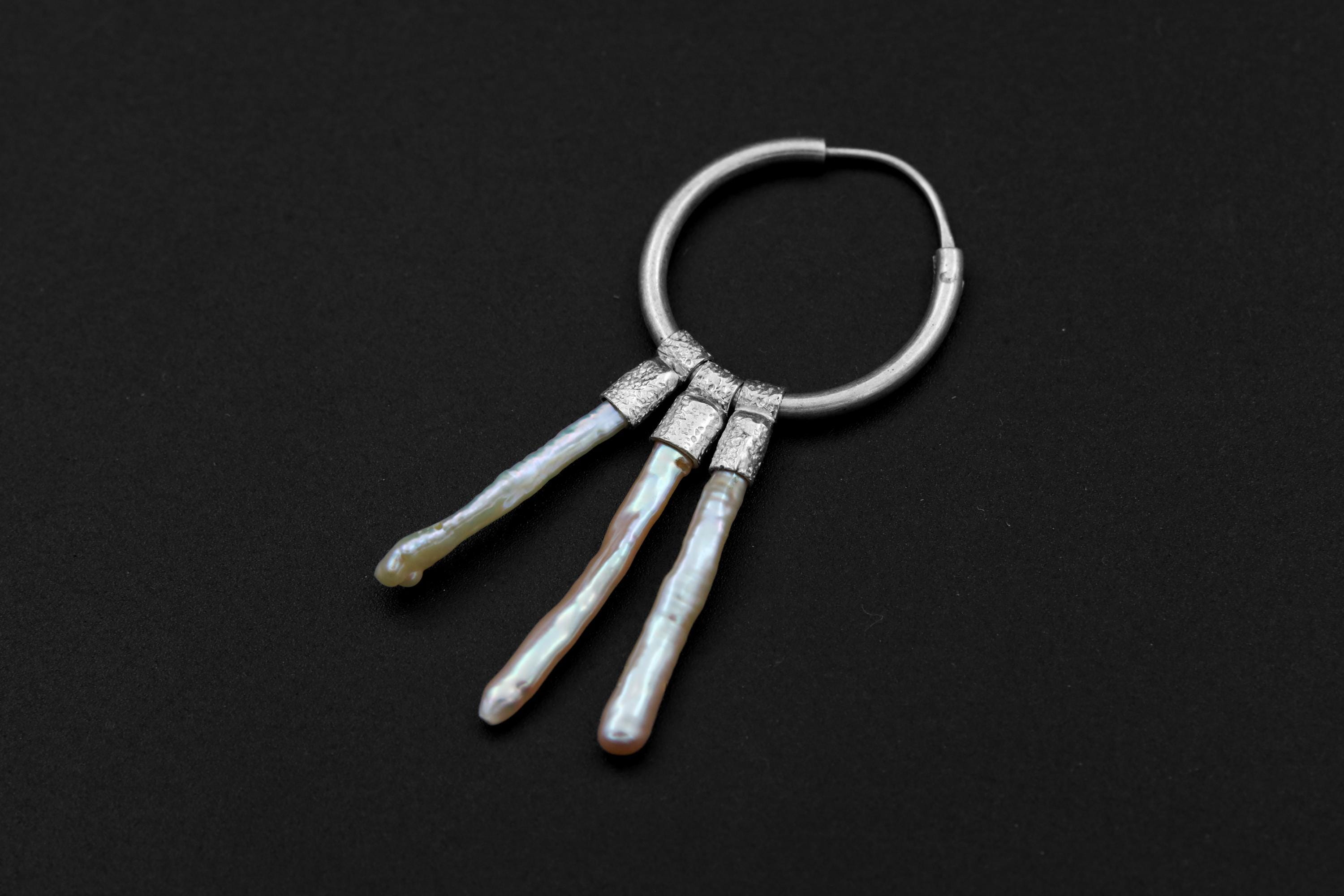 Moonlit Pearl sterling silver hoop earring shown on dark background with stacked Pearl movement.