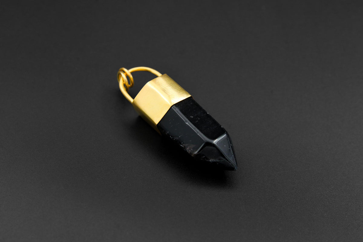 Large Smoky Quartz point pendant shown on dark background with 18k gold-plated bronze cap and deep black crystal.