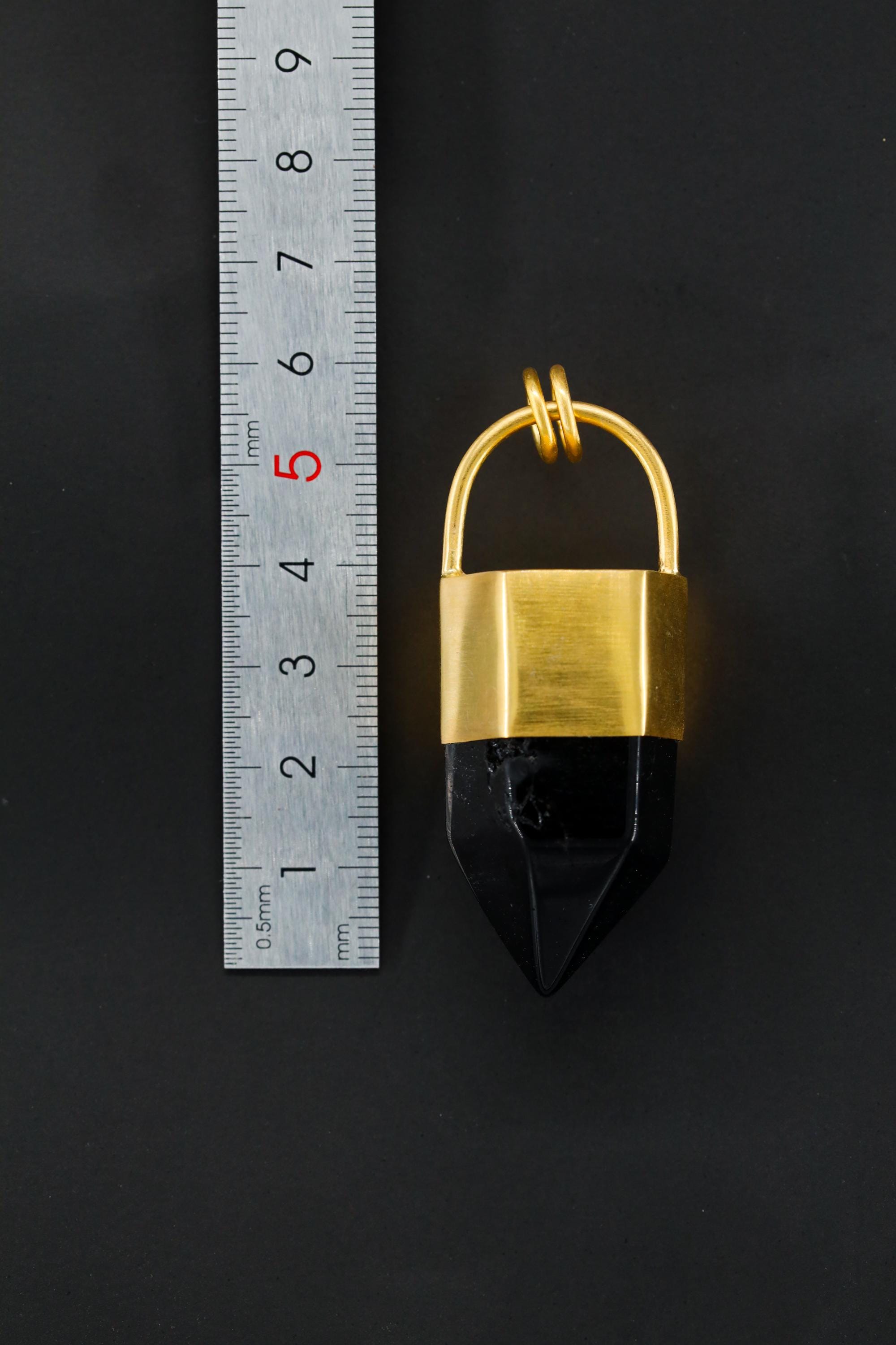 Large Smoky Quartz point pendant shown beside a ruler for scale, measuring approximately 6 cm long.