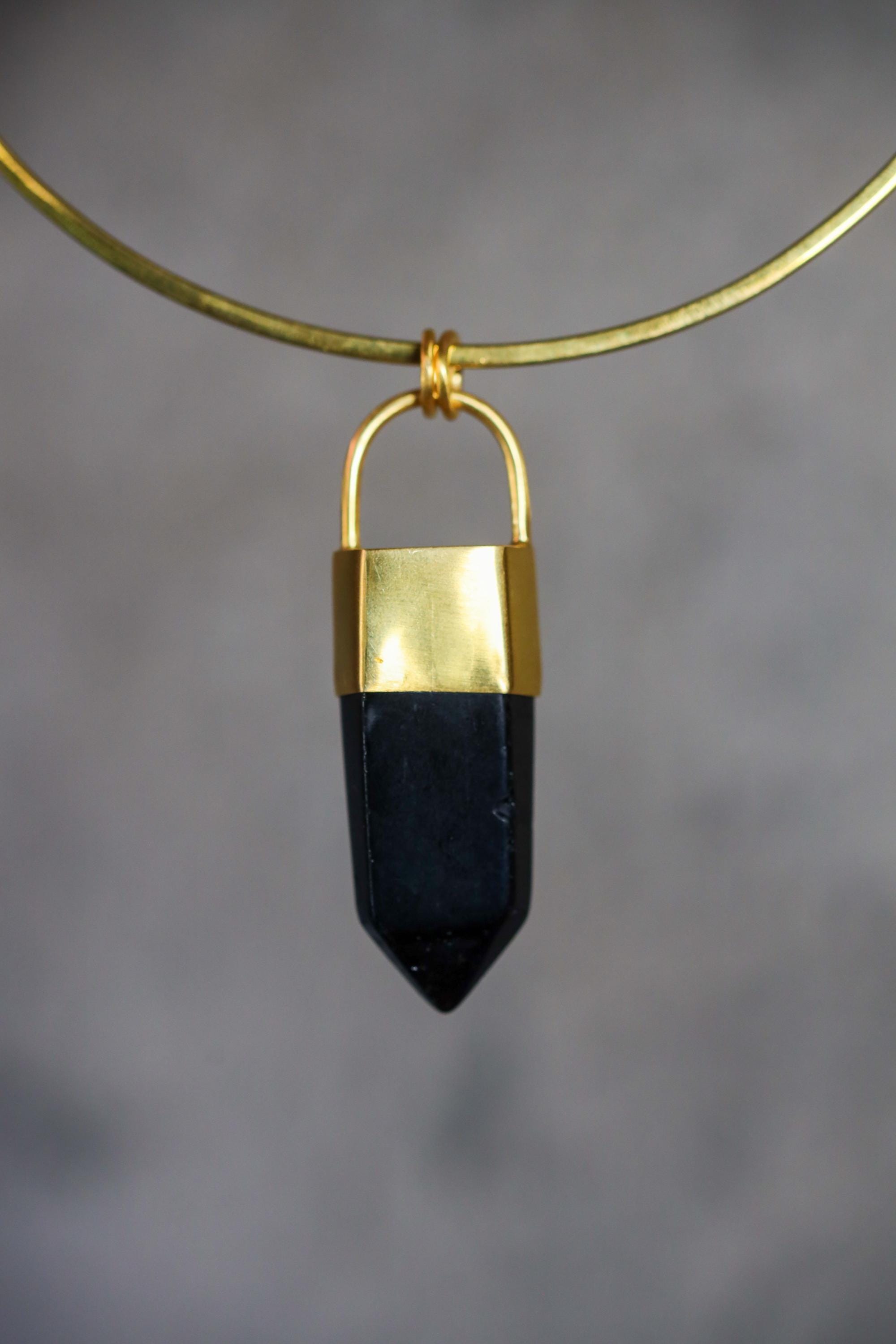 Close-up of dark Smoky Quartz point pendant showing polished crystal facets, gold-plated cap, and strong black-gold contrast.