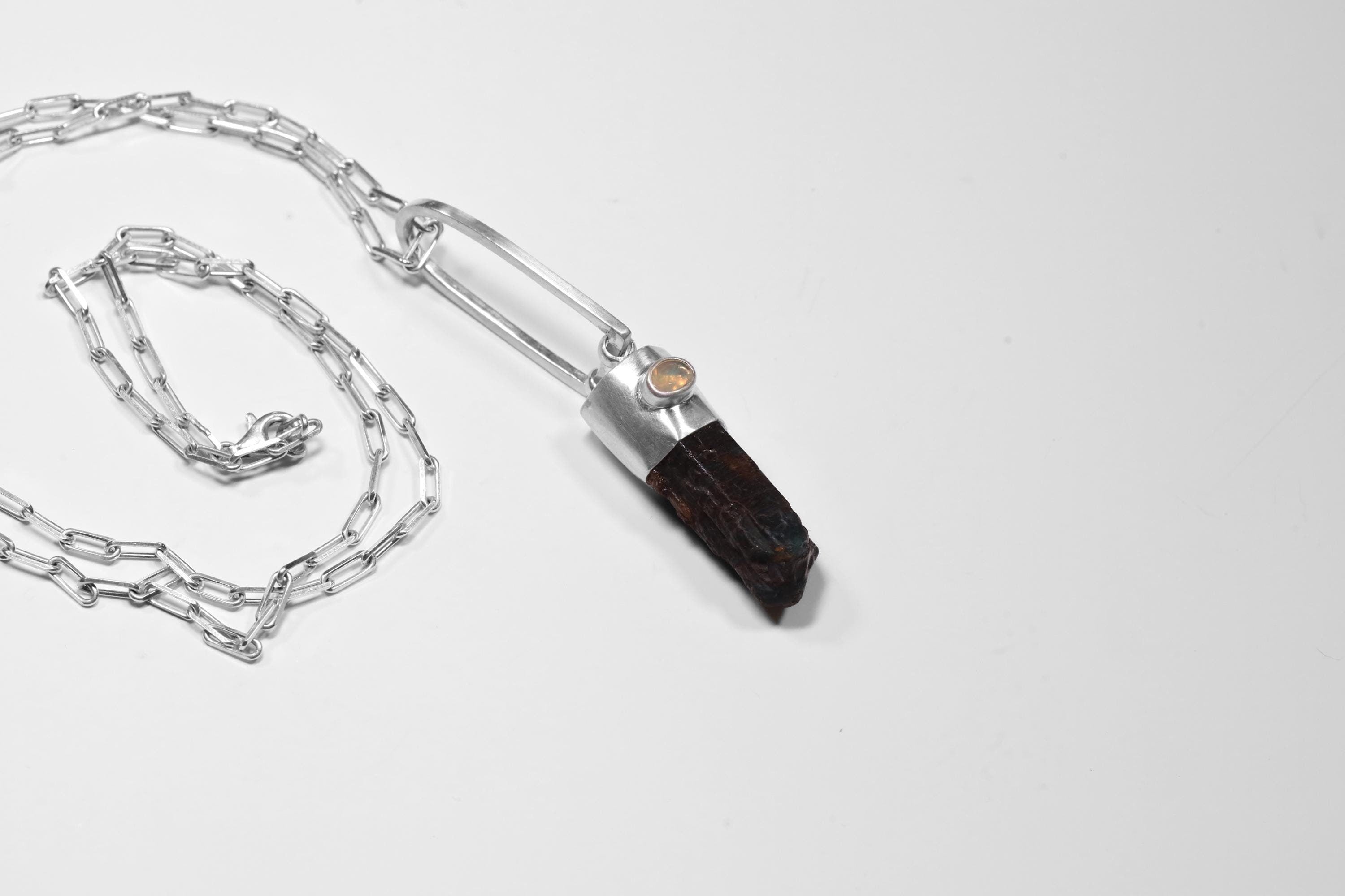 Blue Apatite Ethiopian Opal pendant shown with sterling silver chain, featuring a blue generator point and small opal accent.
