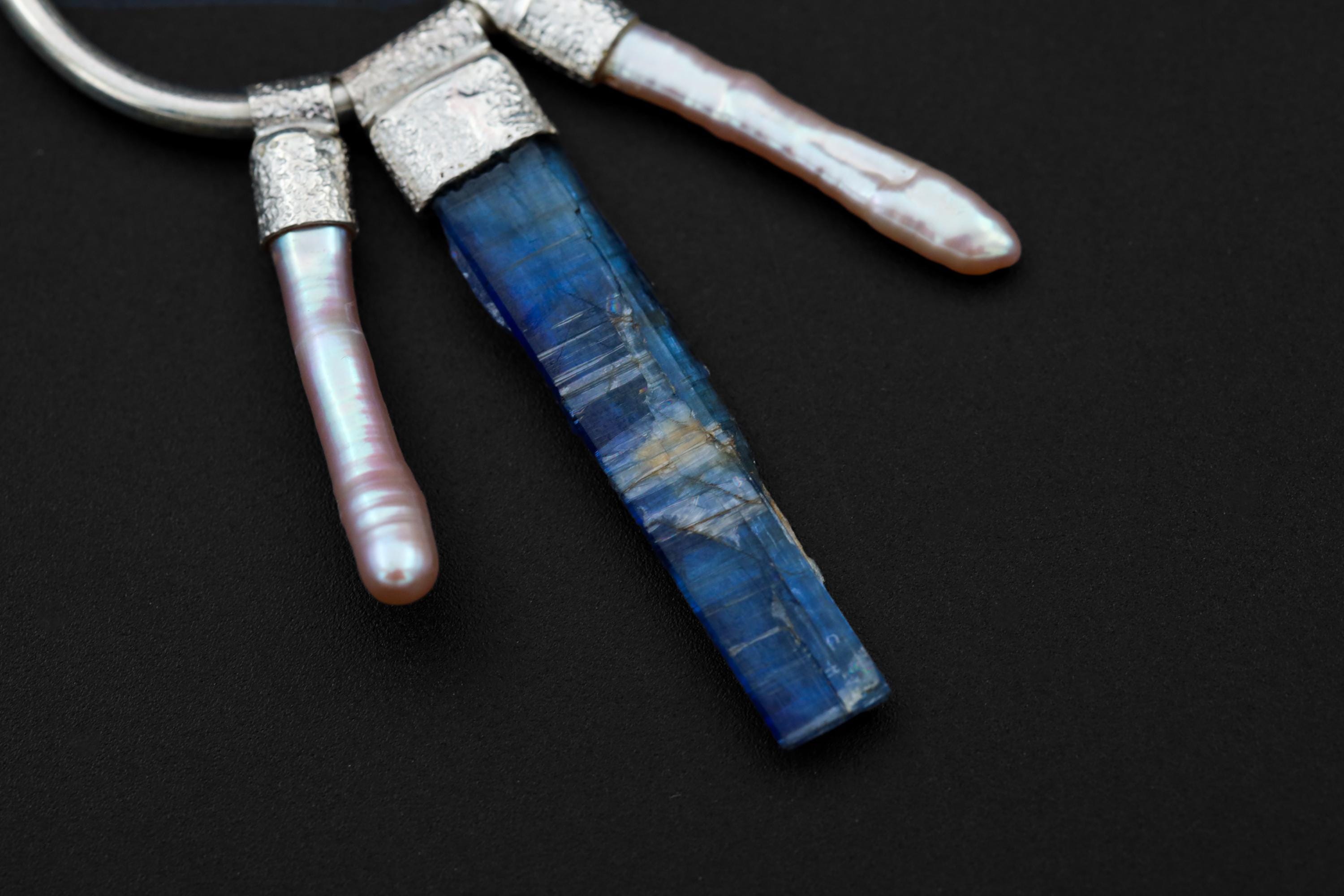 Close-up of raw Blue Kyanite and Pearl dangles on sterling silver hoop earrings with handmade silver details.