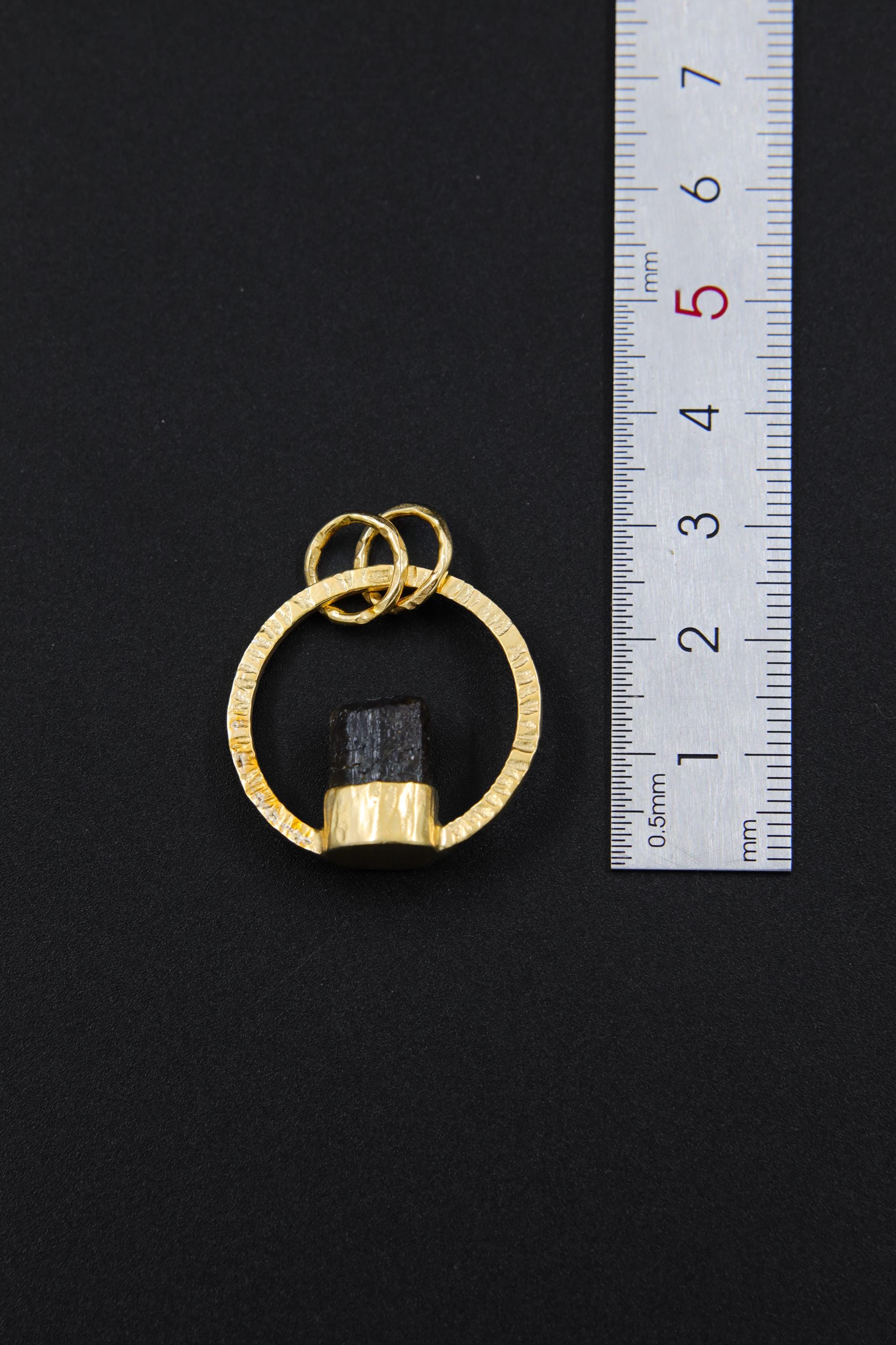 Himalayan Dravite Tourmaline halo pendant shown beside a ruler for scale, measuring approximately 3 cm high including bails.