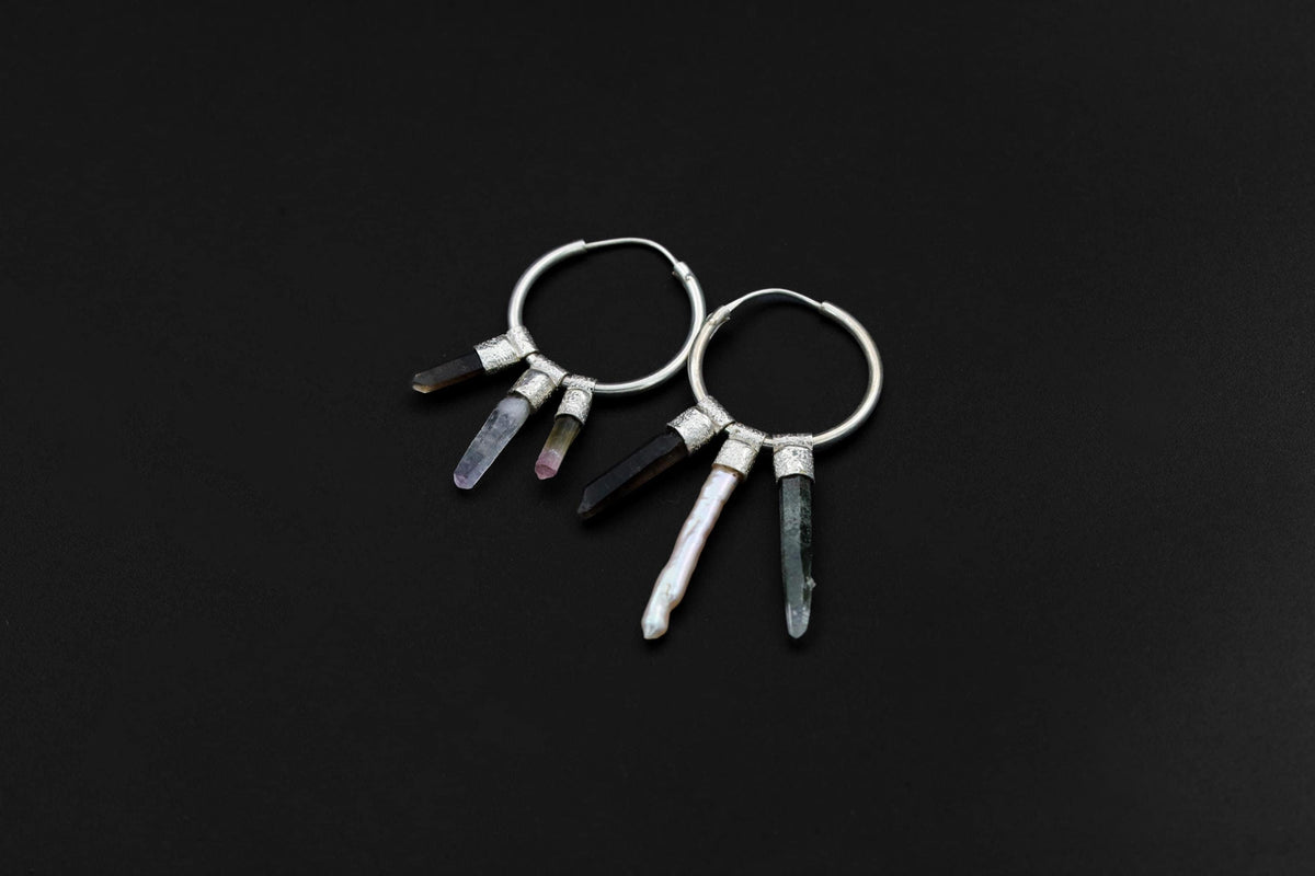 Celestial Gatherer crystal stack hoop earrings shown on dark background with sterling silver hoops and mixed gemstone dangles.