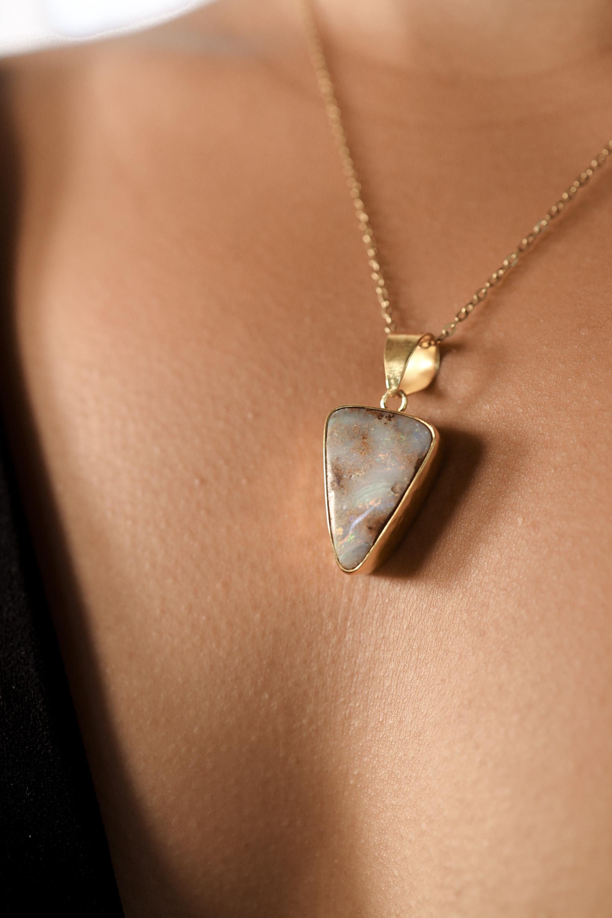 Lightning Ridge White Opal pendant shown worn on the chest, with adjustable necklace and warm gold-plated sterling silver setting.
