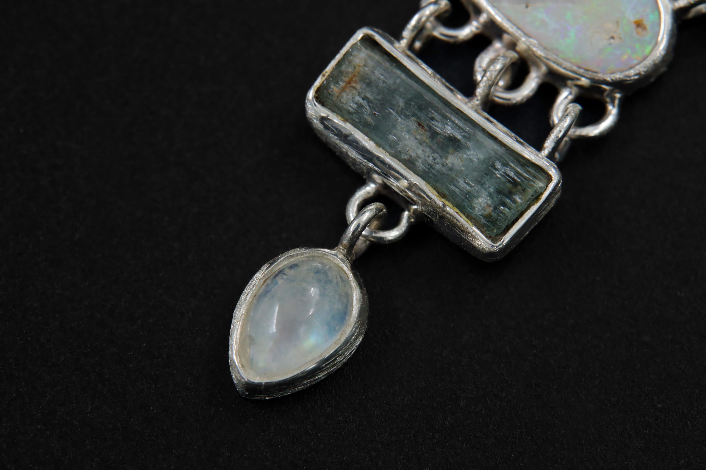 Close-up of square Aquamarine and pear-shaped Blue Moonstone in a sterling silver gemstone necklace.