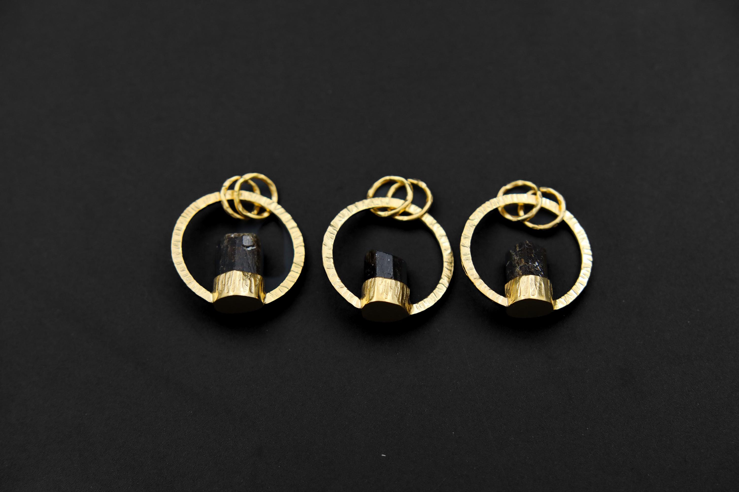 Collection of Himalayan Dravite Tourmaline halo pendants in 18k gold-plated sterling silver on a dark background.