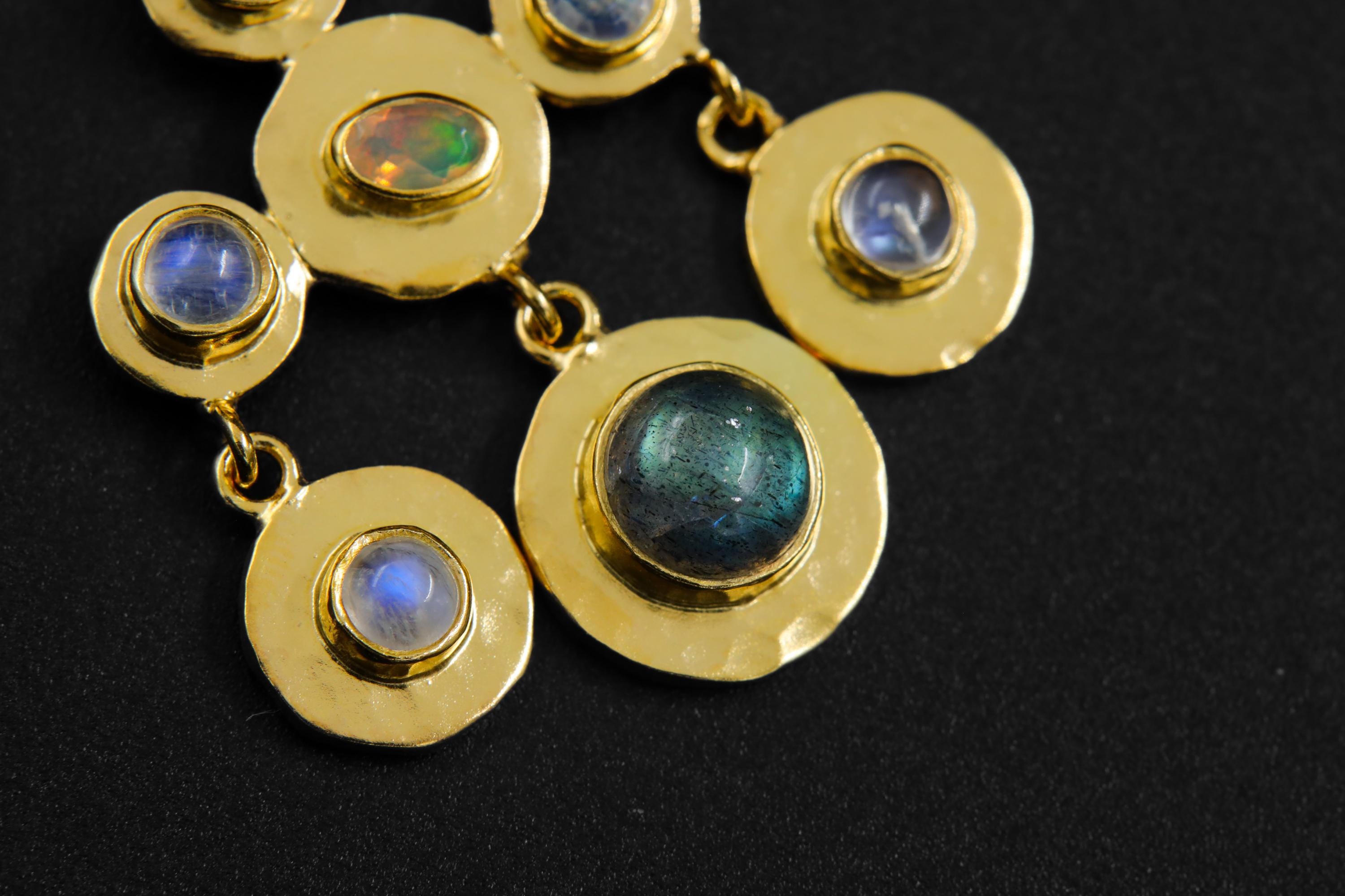 Detail view of Blue Moonstone, Ethiopian Opal, and Labradorite stones in a clustered gold-plated pendant setting.