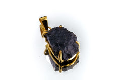 Cosmic Relic Darwin Glass pendant shown on white background with raw black tektite and gold-plated silver.