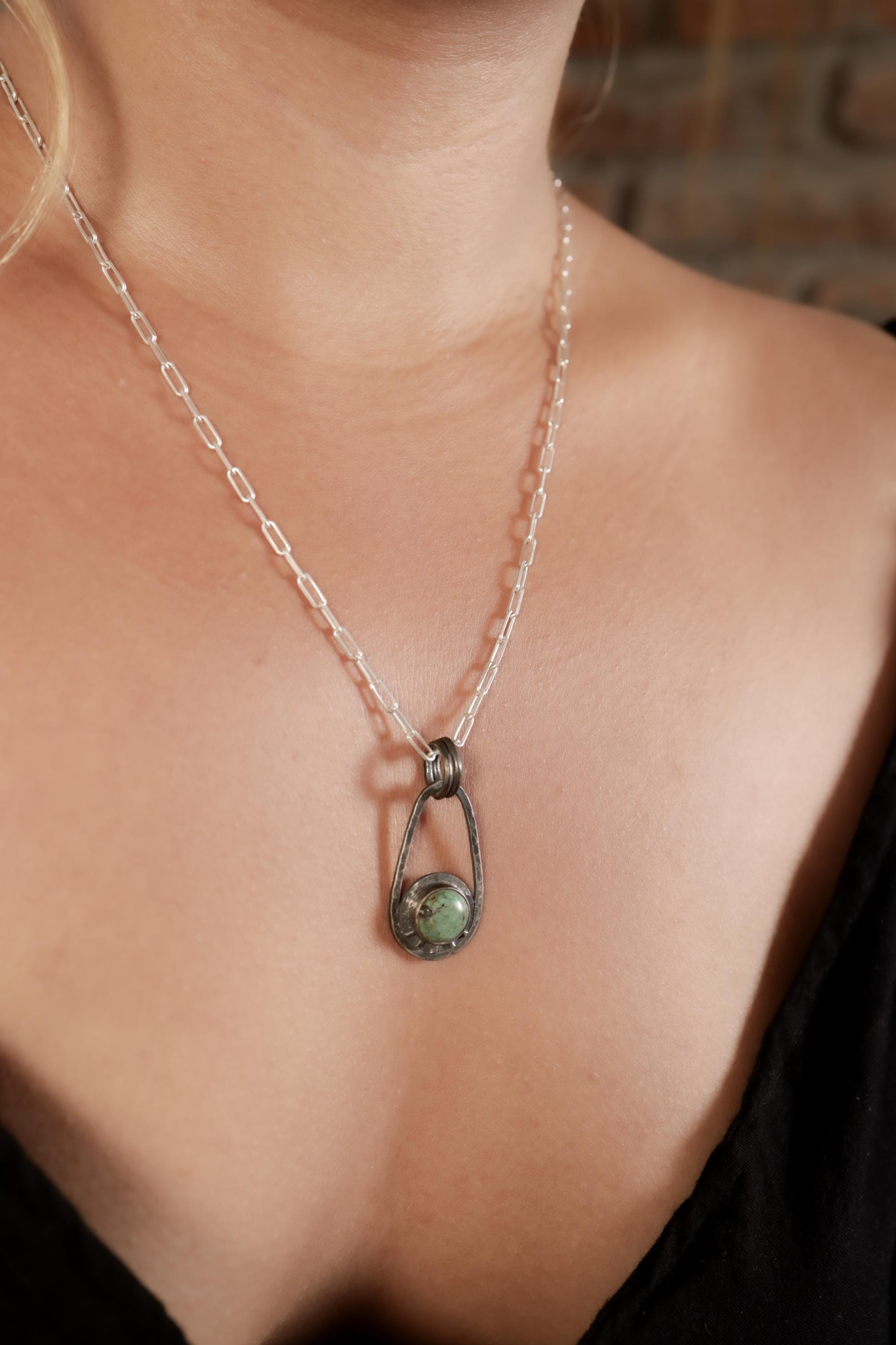Single Royston Turquoise pendant on black background with oxidized sterling silver frame, dual bail, and celestial ray accents.