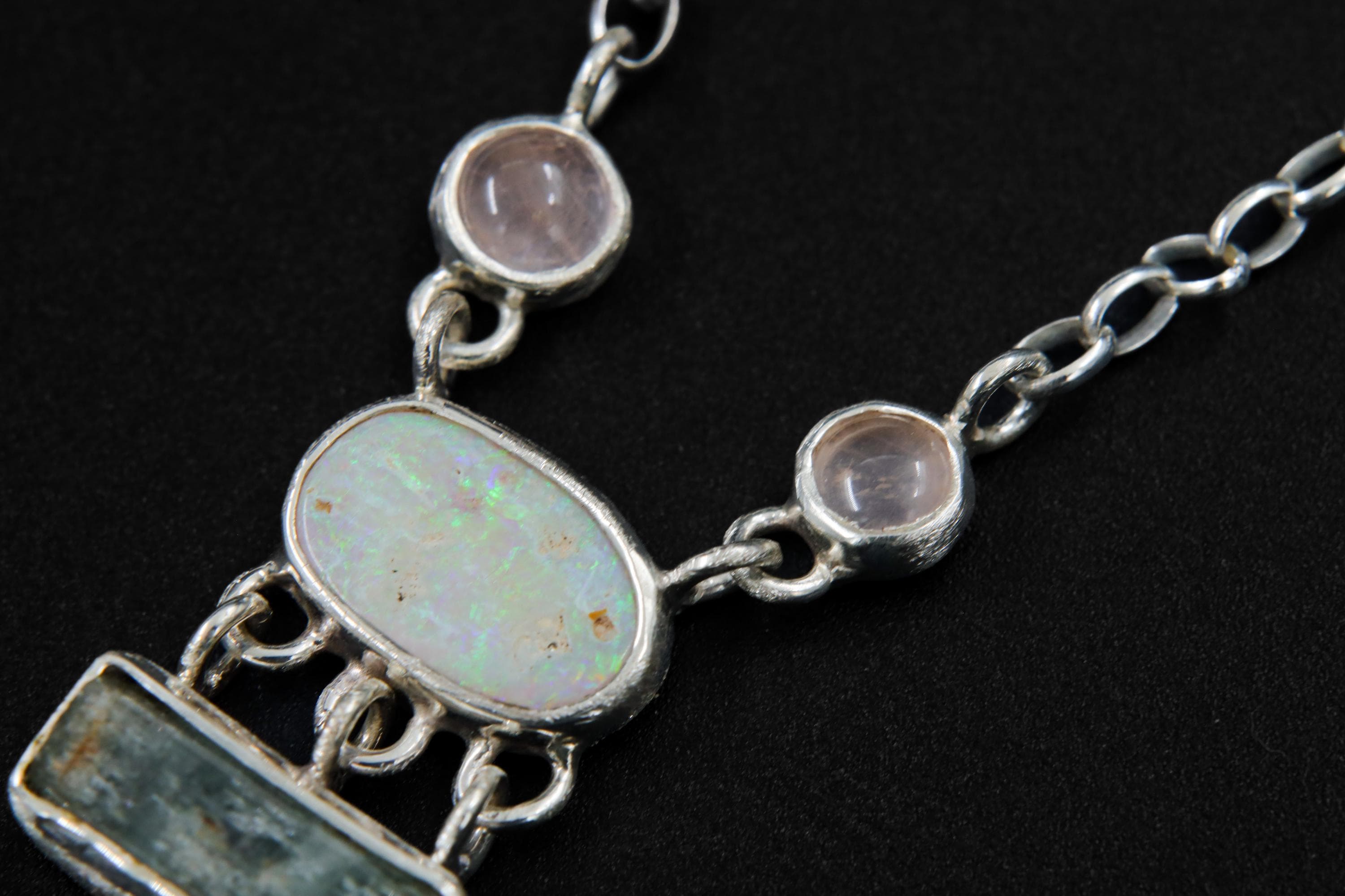 Close-up of Opal and Rose Quartz stones in brushed sterling silver bezels with soft luminous gemstone colour.