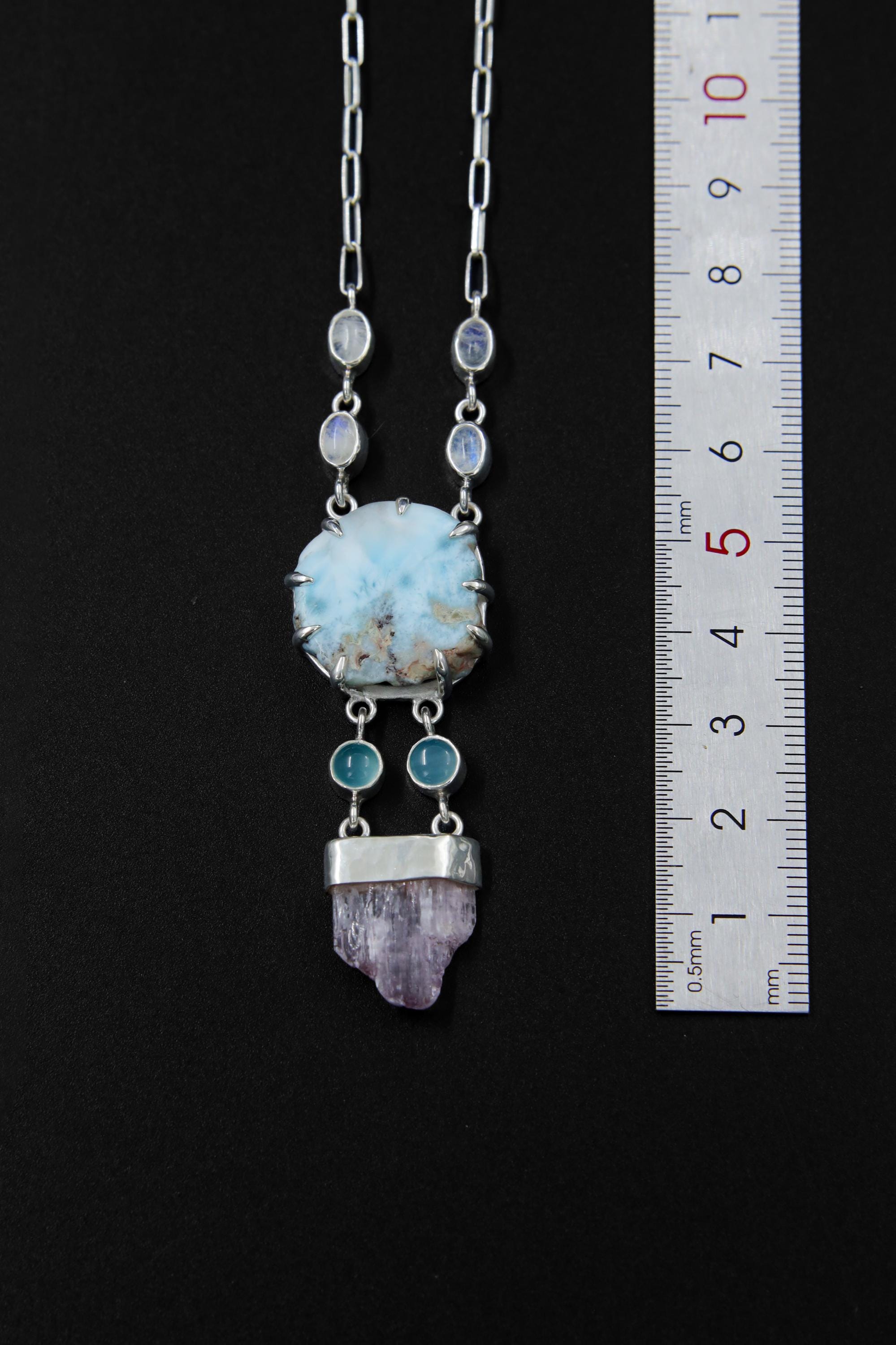 Larimar and Kunzite pendant necklace shown beside a ruler for scale, with wire link chain and flowing gemstone dangle layout.