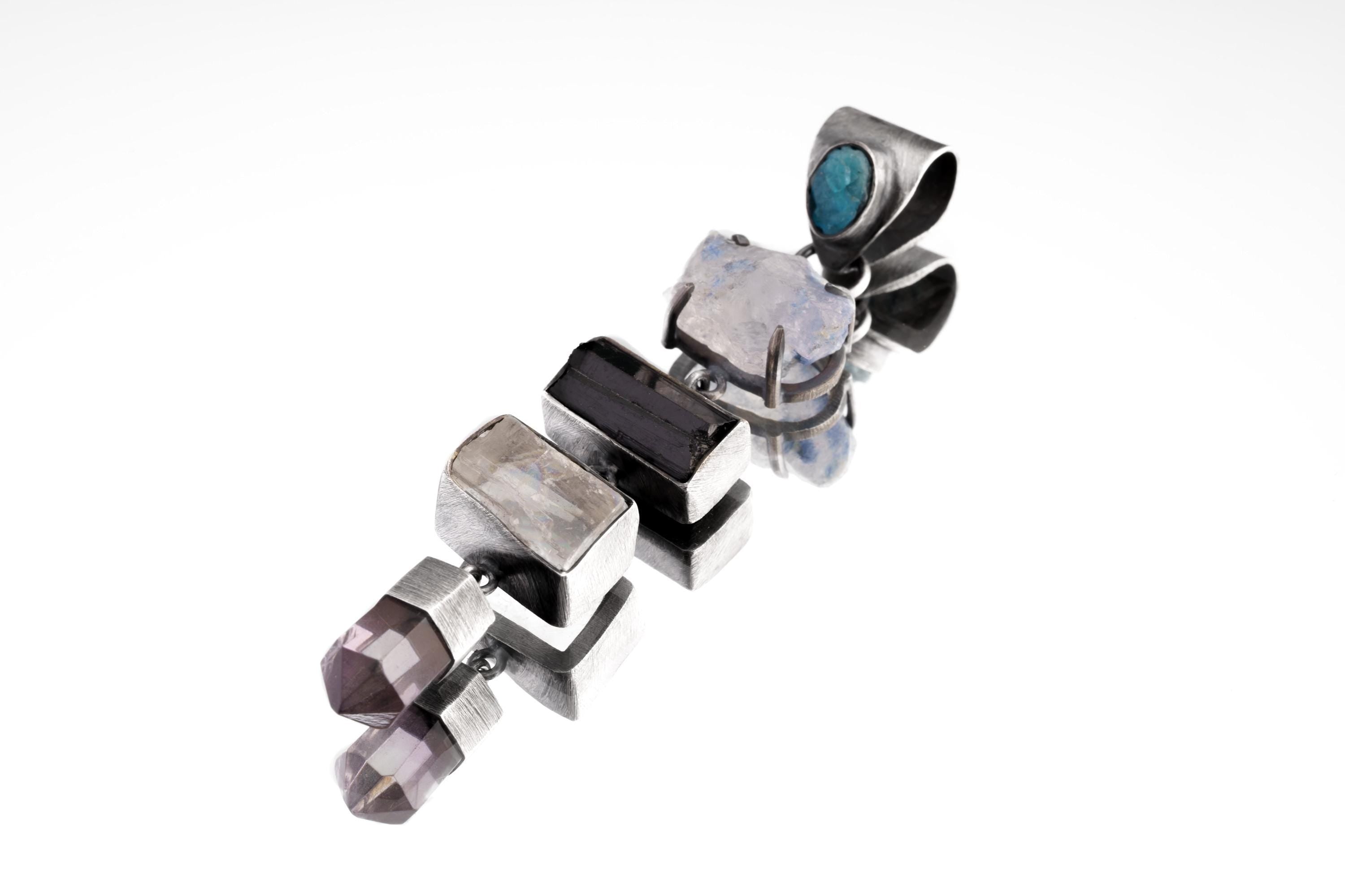 Multi-stone oxidized sterling silver pendant shown on a white background with Blue Apatite, Tanzanite, Black Tourmaline, Selenite, and Amethyst.
