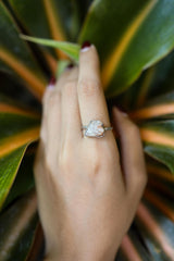 Sunstone sterling silver ring shown on clear quartz, with pale golden feldspar stone and handmade polished silver setting.