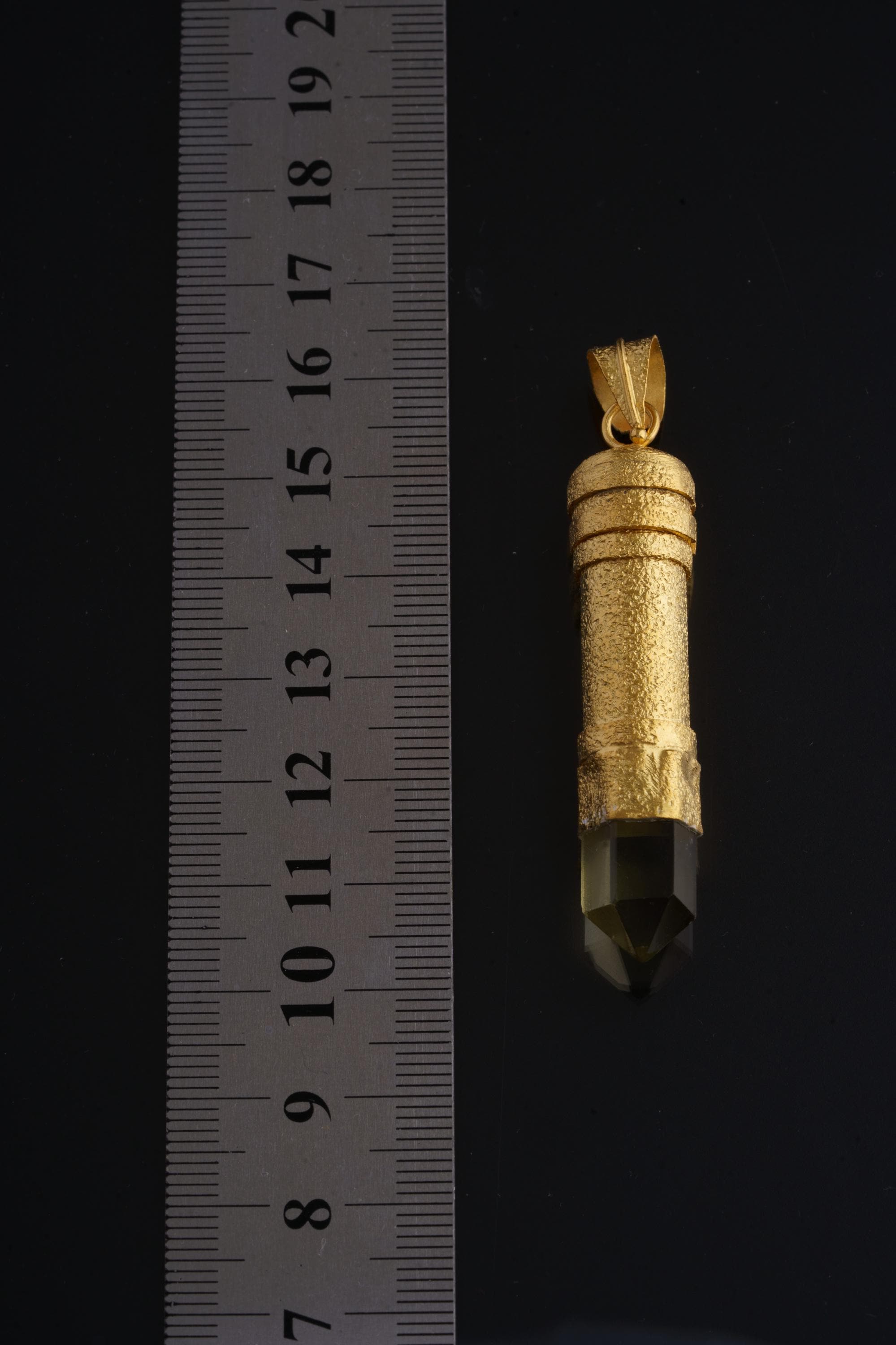 Smokey Quartz gold-plated capsule pendant shown beside a ruler for scale, measuring approximately 6 cm long.