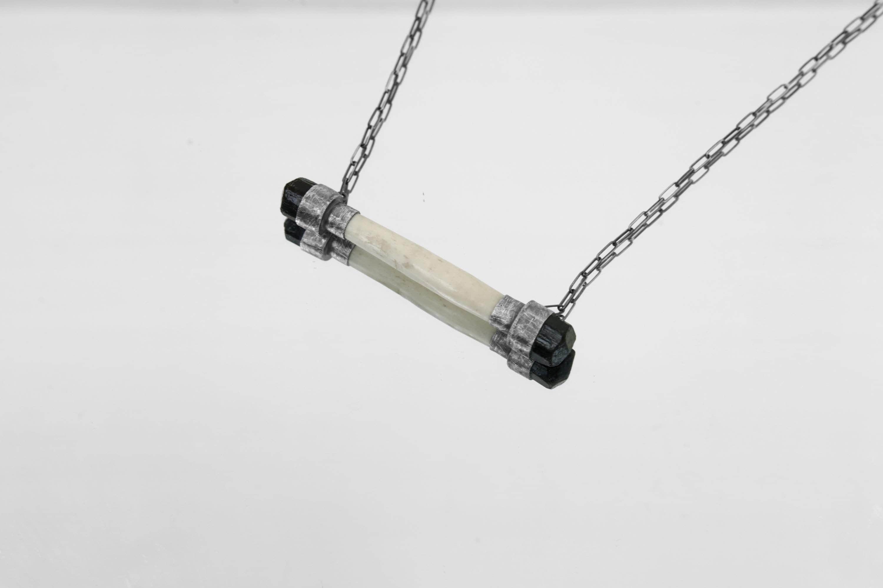 Black Tourmaline and antique bone pendant shown on a light background with oxidized 925 sterling silver and box chain.