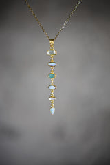 Zircon Aquamarine Australian Opal and Blue Moonstone pendant on a dark background, showing long linked gemstone cascade.