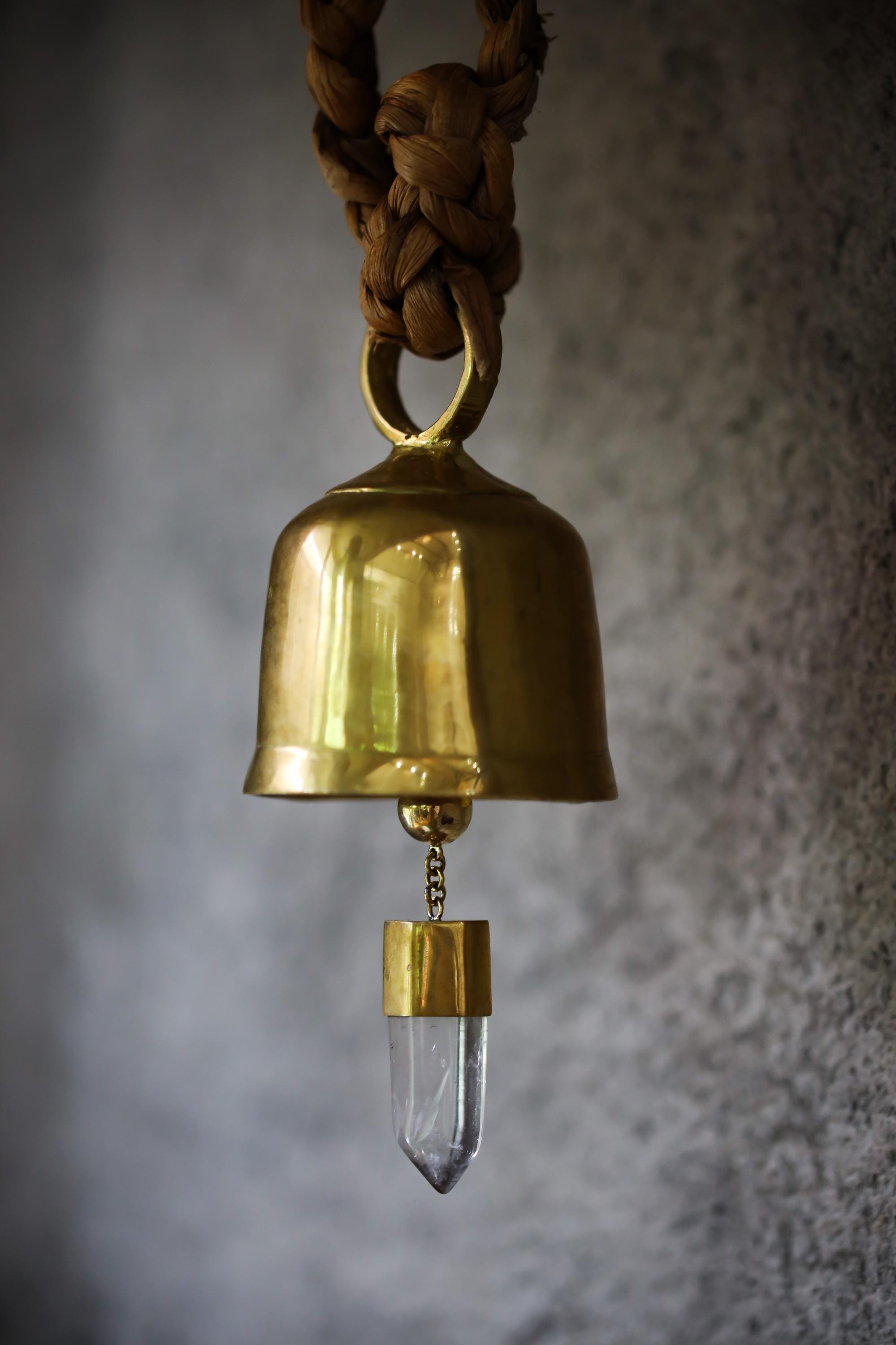 Large Clear Quartz Gold Plated Prayer Bell shown close-up with warm golden shine and suspended crystal point.