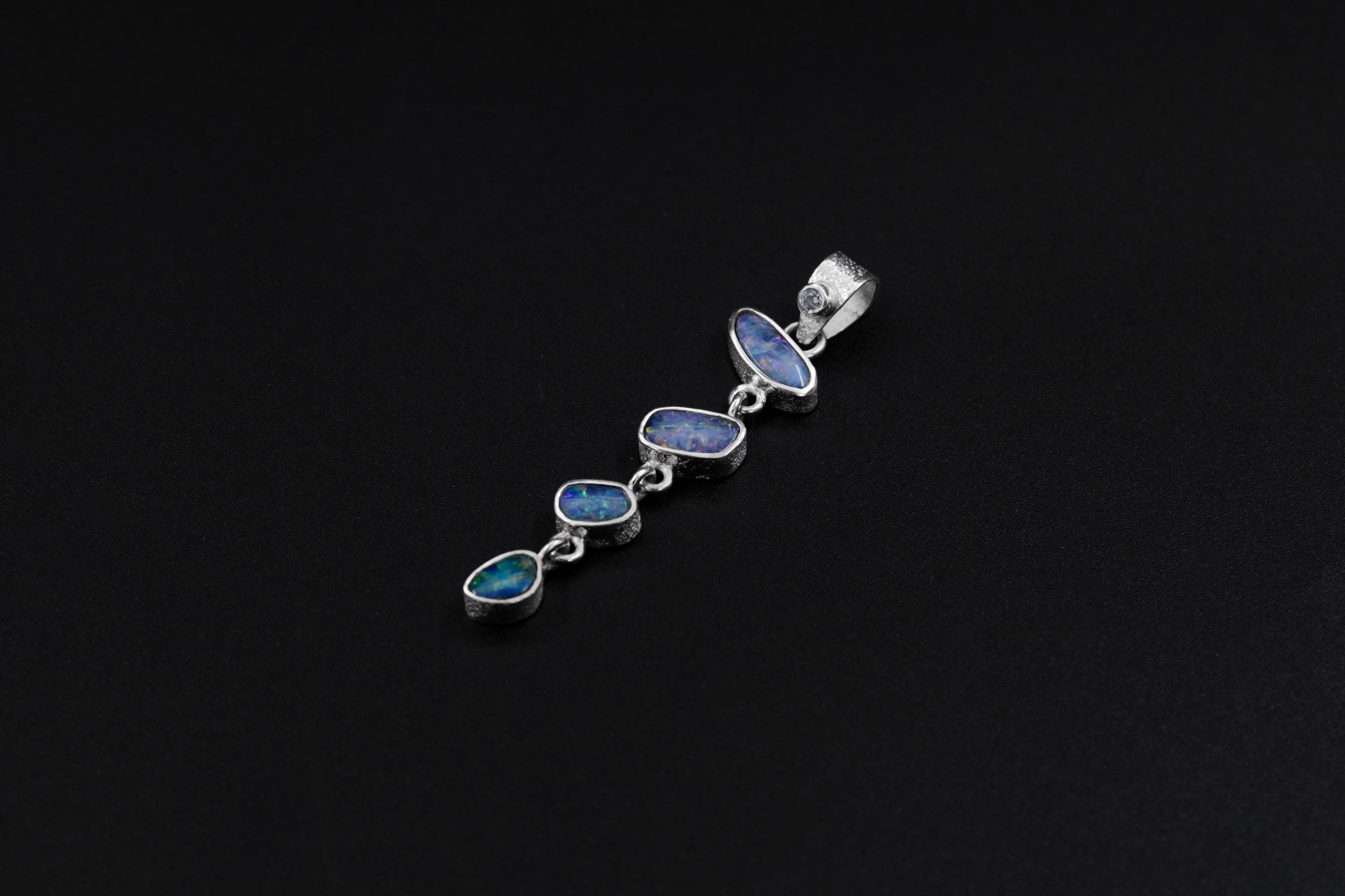Herkimer Diamond and Australian Opal Doublet pendant on black background with textured sterling silver settings.