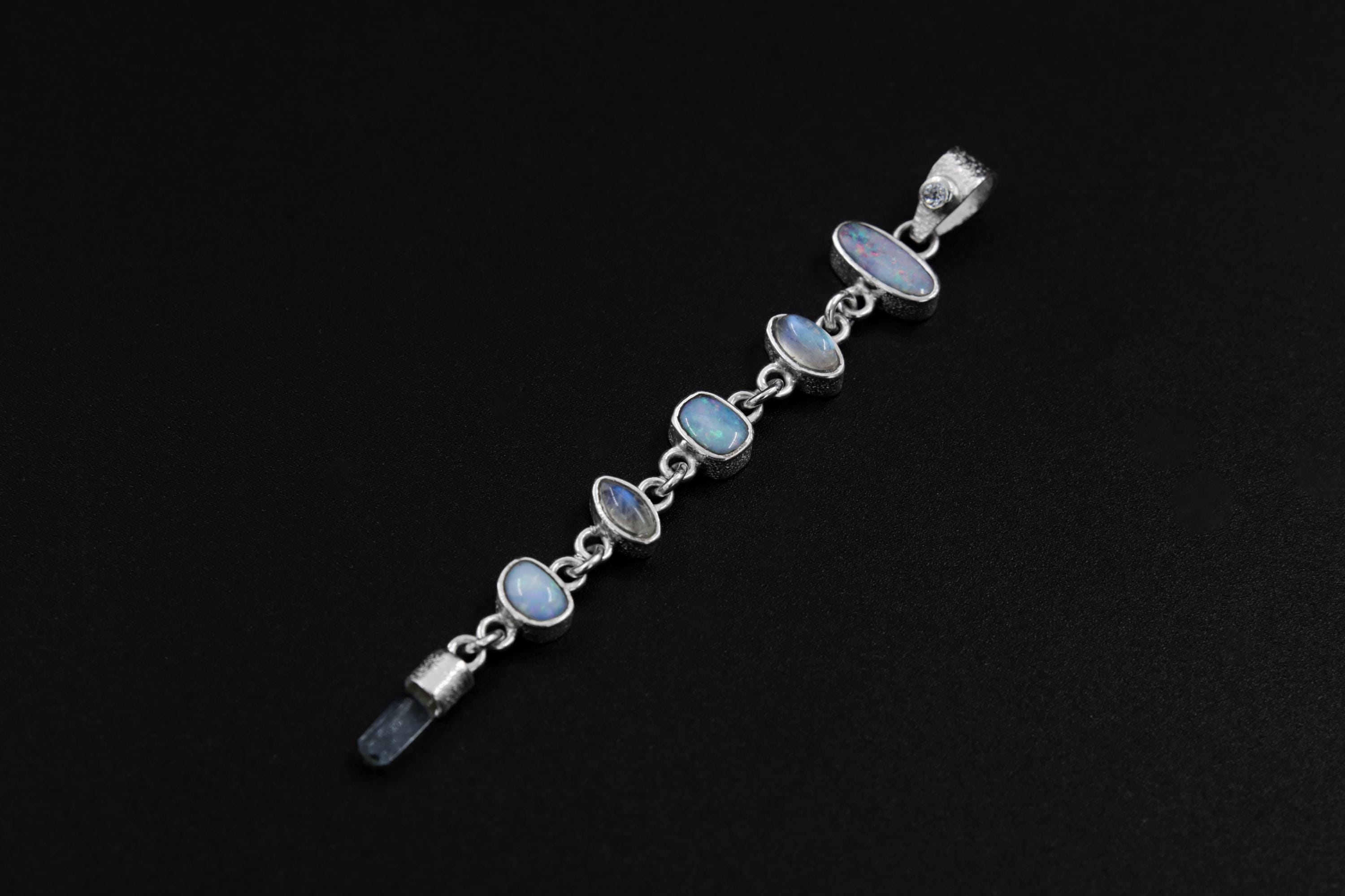 Close-up of open-back sterling silver bezel setting holding Baroque-style gemstone detail in a multi-stone cascade pendant.