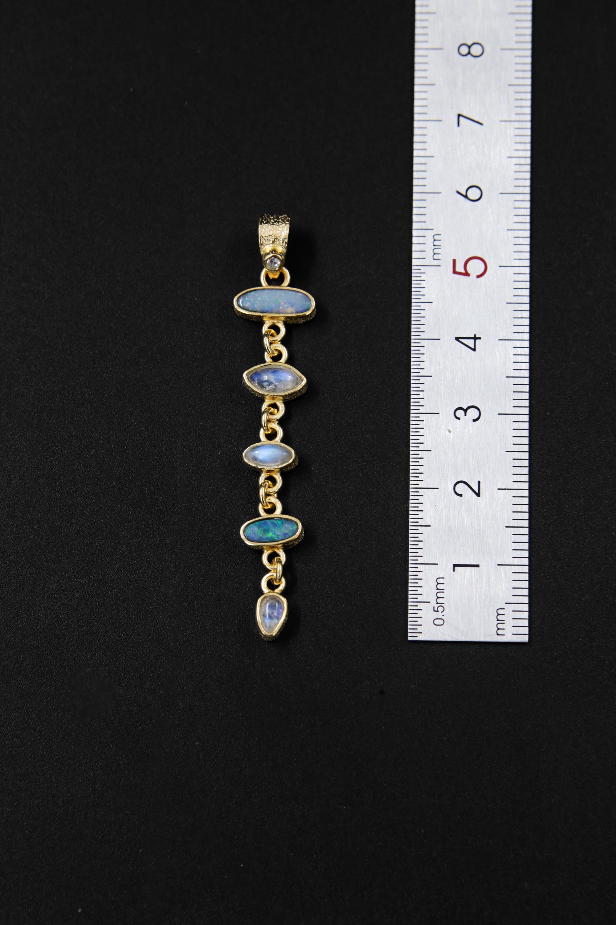 White Zircon Australian Opal Blue Moonstone Herkimer pendant shown beside a ruler for scale, measuring approximately 5.5 to 6 cm long.