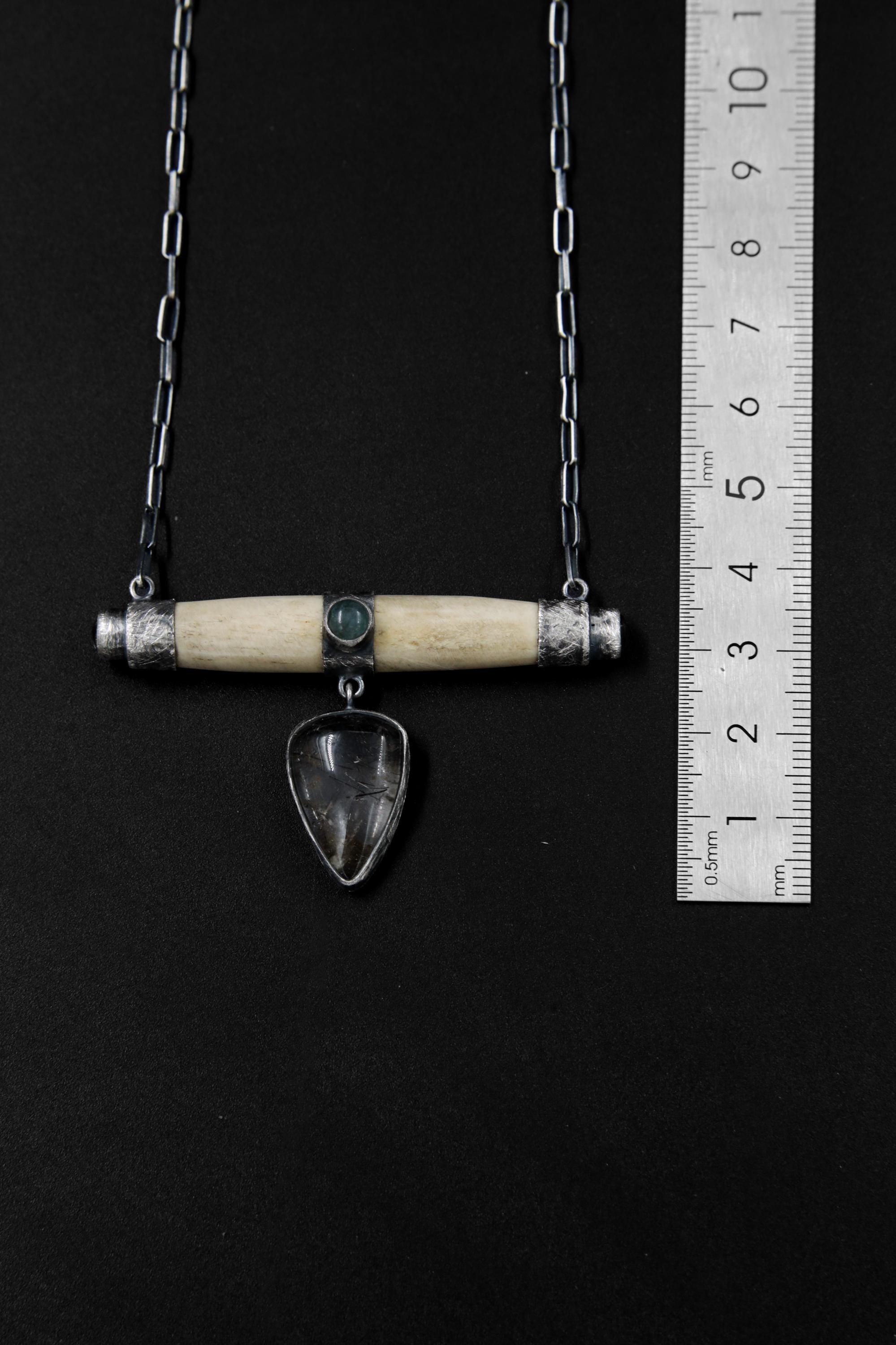 Aquamarine Bone Black Rutile Quartz pendant shown beside a ruler for scale, with oxidized silver and horizontal bone design.